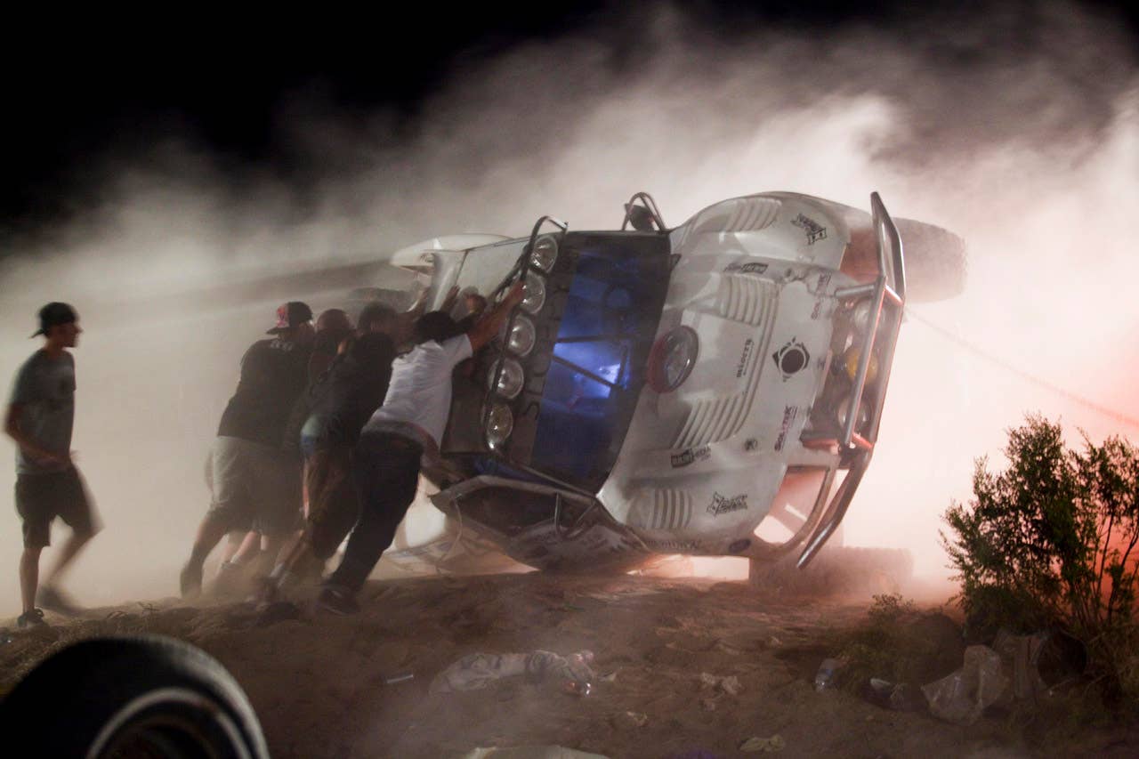 Workers push an overturned off-road race truck upright Sunday, Aug. 15, 2010 after it went out of control and ran into a crowd of spectators during a race in Lucerne Valley, Calif., on Saturday. At least eight people were killed during the incident about 100 miles east of Los Angeles.(AP Photo/Francis Specker)