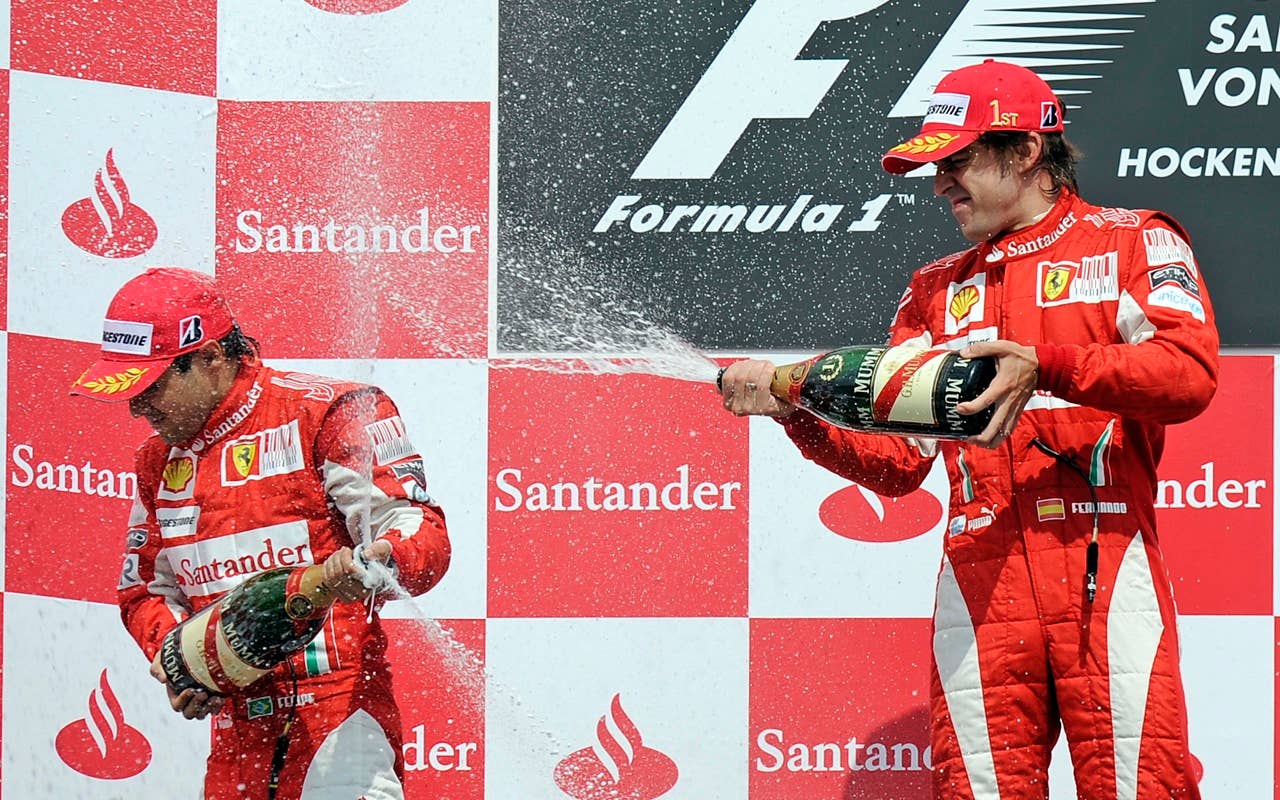 Ferrari's Fernando Alonso of Spain, right, sprays champagne to second placed teammate Felipe Massa of Brazil, left, on the podium after winning the German Formula One Grand Prix in Hockenheim, Germany,  Sunday, July 25, 2010. (AP Photo/Martin Meissner)
