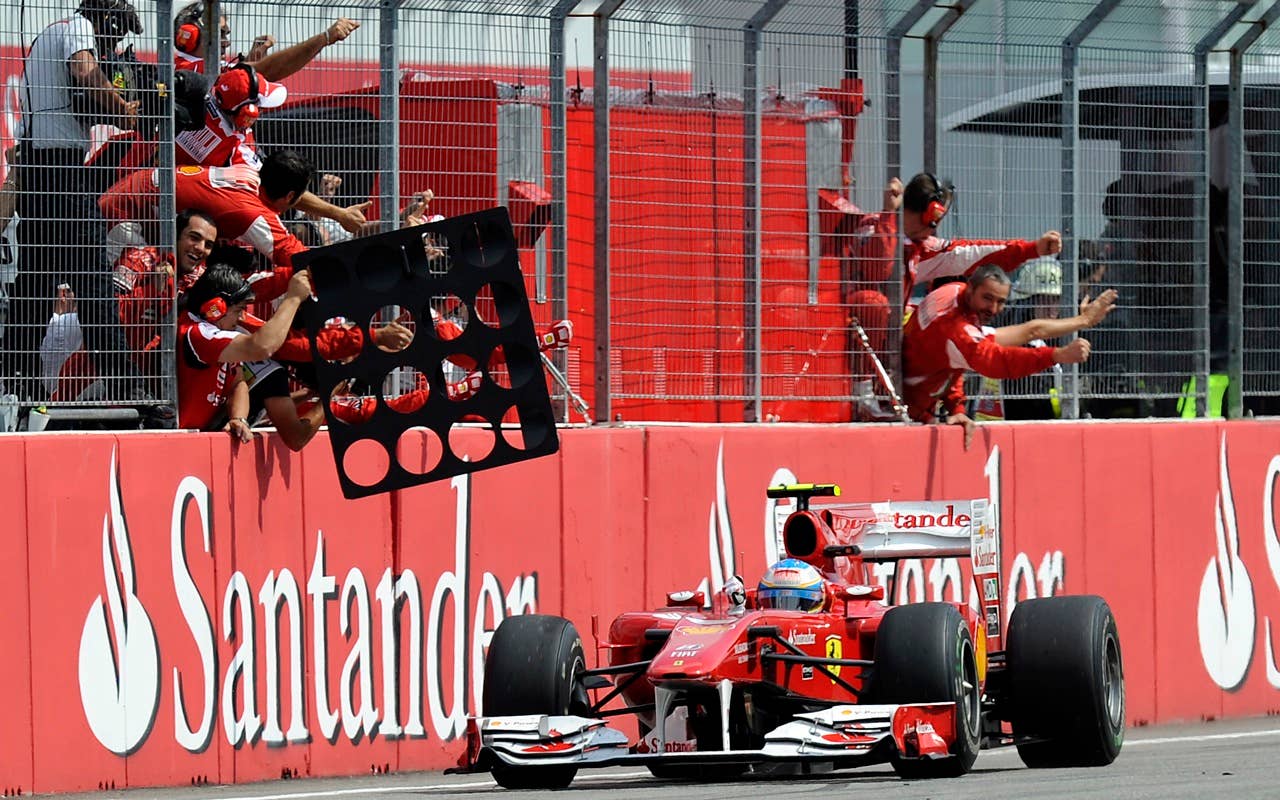 Ferrari Formula One driver Fernando Alonso of Spain celebrates with his team after passing the finish line as winner of the German Formula One Grand Prix in Hockenheim, Germany,  Sunday, July 25, 2010. (AP Photo/Martin Meissner)