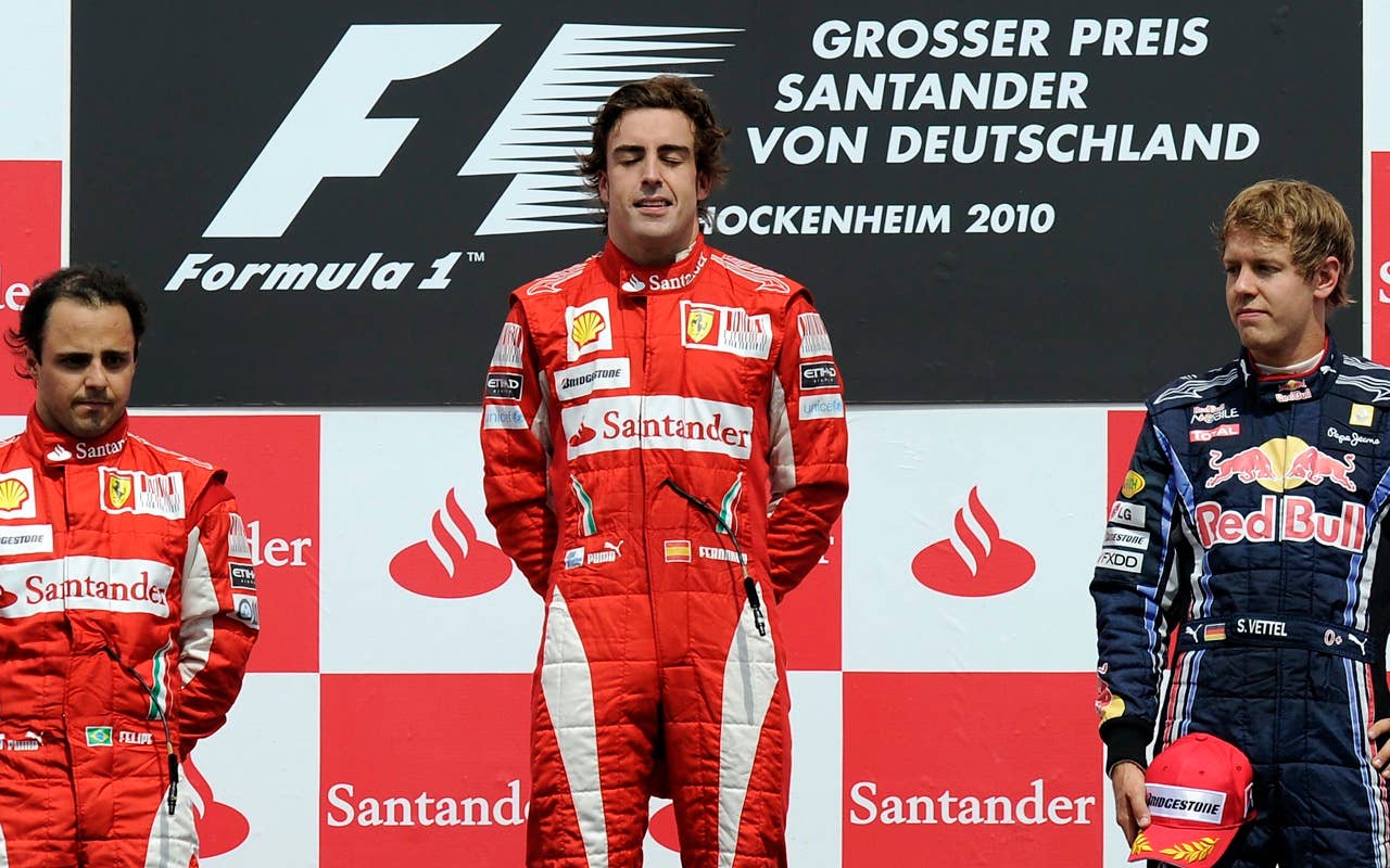 Ferrari Formula One driver Fernando Alonso of Spain, center, closes his eyes during the national anthem after winning the German Formula One Grand Prix in Hockenheim, Germany,  Sunday, July 25, 2010. Ferrari driver Felipe Massa of Brazil, left, finished second, German Red Bull driver Sebastian Vettel, right, finished third. (AP Photo/Martin Meissner)