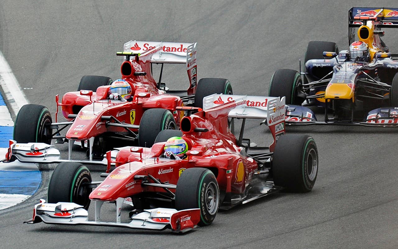 Ferrari's Fernando Felipe Massa, in front of Fernando Alonso, left, overtakes Red Bull driver Sebastian Vettel, right, at the first curve of the German Formula One Grand Prix in Hockenheim, Germany,  Sunday, July 25, 2010. Alonso won the race in front of Massa and third placed Vettel. (AP Photo/Martin Meissner)