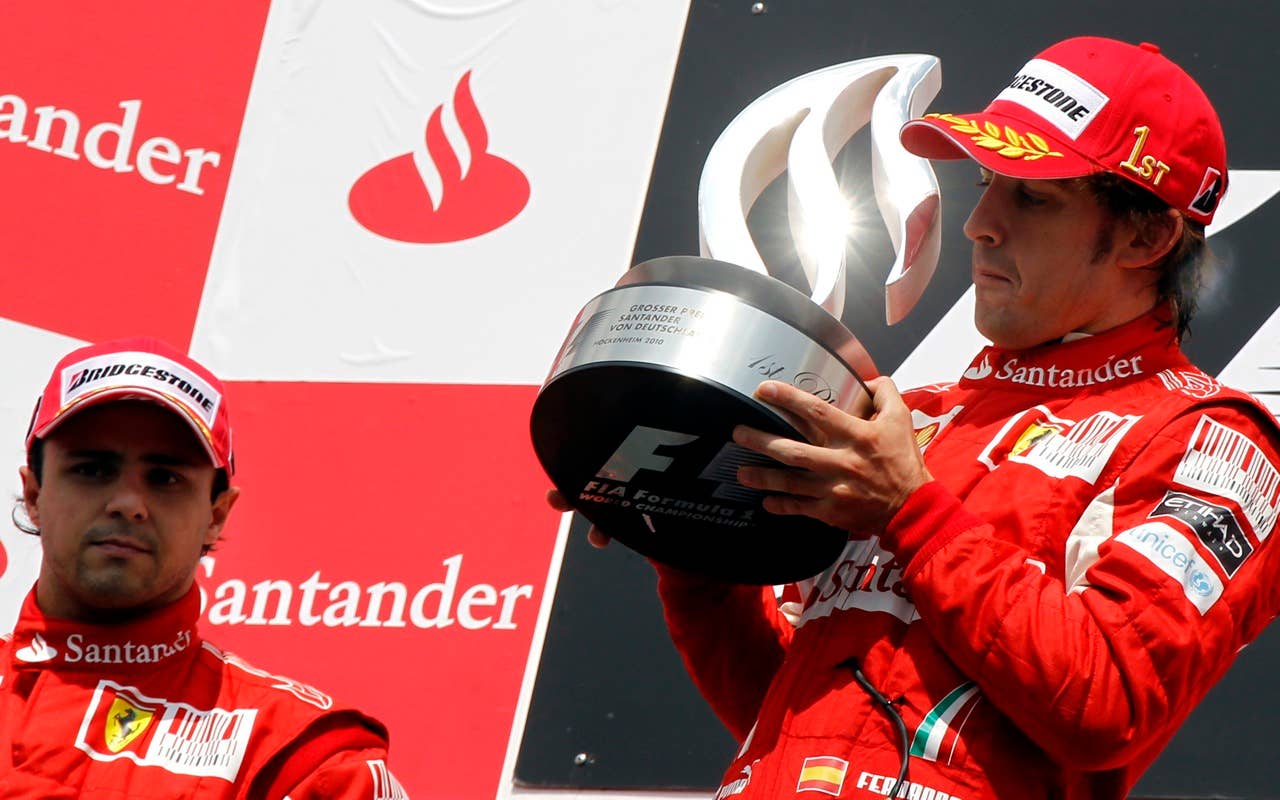 Ferrari Formula One driver Fernando Alonso of Spain, right, lifts the trophy next to second placed Felipe Massa of Brazil after winning the German Formula One Grand Prix in Hockenheim, Germany, Sunday, July 25, 2010. (AP Photo/Matthias Schrader)