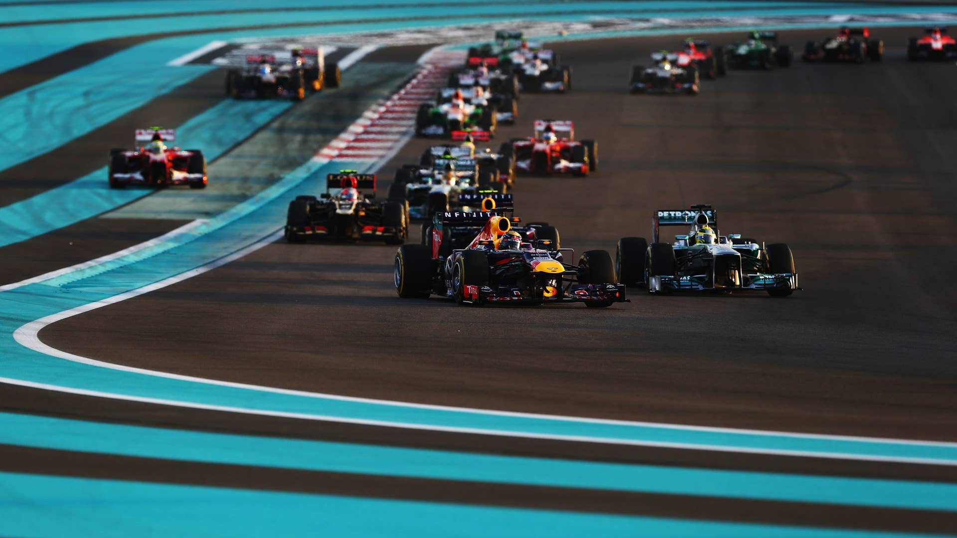 ABU DHABI, UNITED ARAB EMIRATES - NOVEMBER 03: Sebastian Vettel (front left) of Germany and Infiniti Red Bull Racing leads the field through turns one and two at the start of the Abu Dhabi Formula One Grand Prix at the Yas Marina Circuit on November 3, 2013 in Abu Dhabi, United Arab Emirates. (Photo by Paul Gilham/Getty Images)