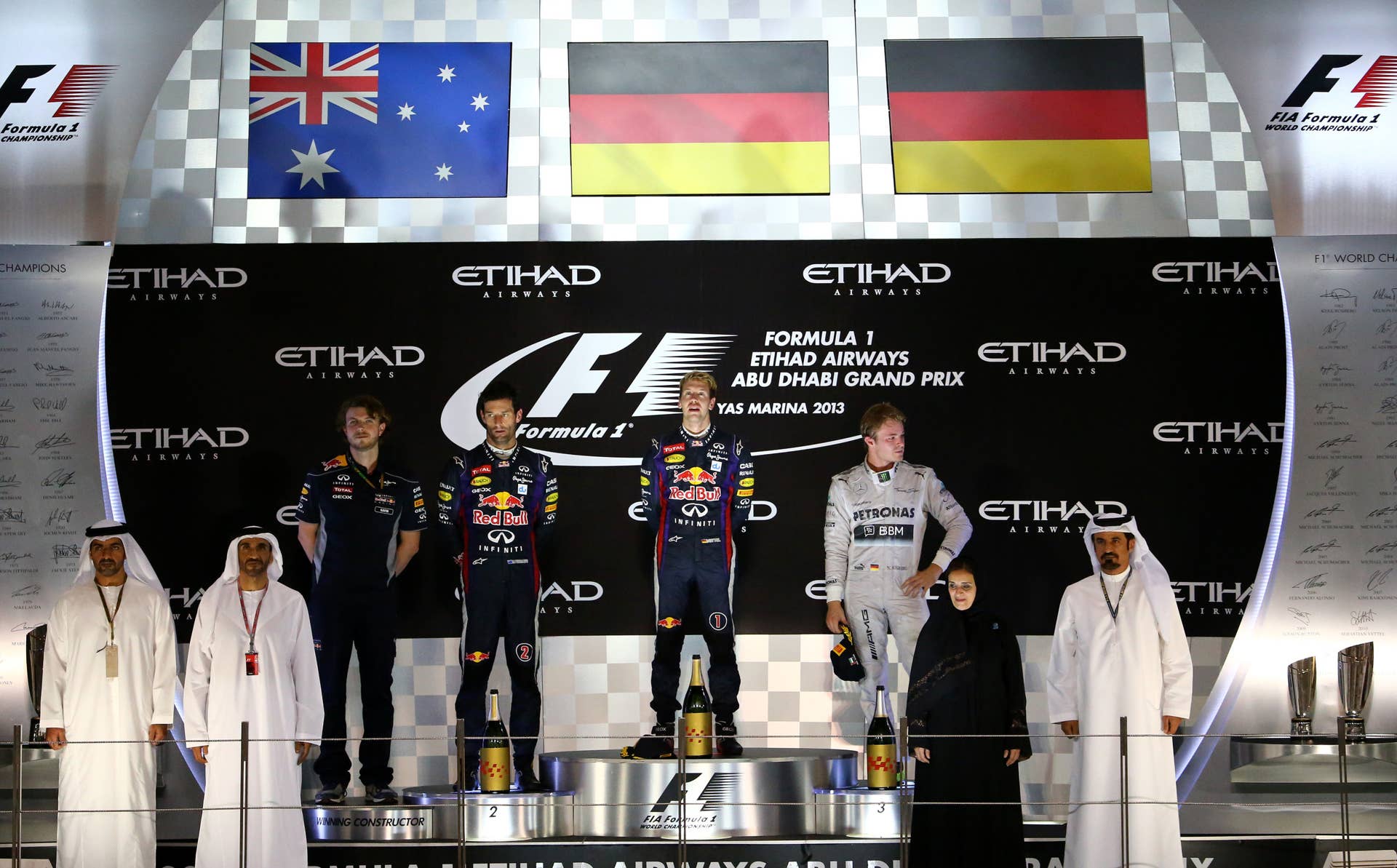 (L to R) Red Bull Racing's Australian driver Mark Webber, Red Bull Racing's German driver Sebastian Vettel and Mercedes'  German driver Nico Rosberg celebrate on the podium at the Yas Marina circuit in Abu Dhabi on November 3, 2013 after the Abu Dhabi Formula One Grand Prix.    AFP PHOTO / MARWAN NAAMANI        (Photo credit should read MARWAN NAAMANI/AFP/Getty Images)