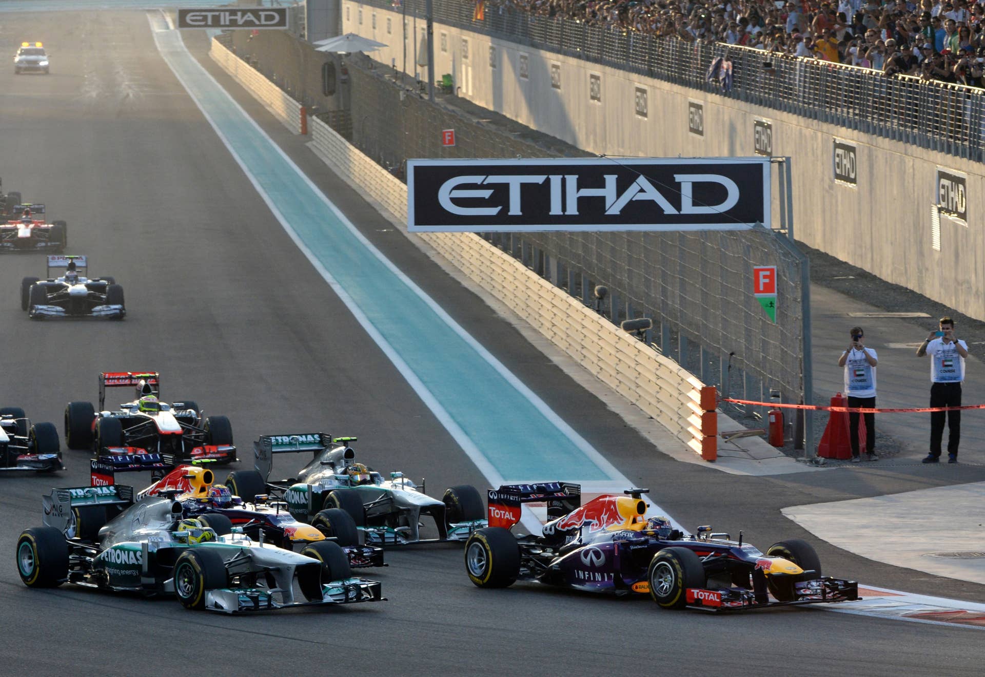 Red Bull Racing's German driver Sebastian Vettel (R) leads after the start of the Abu Dhabi Formula One Grand Prix at the Yas Marina circuit in Abu Dhabi on November 3, 2013.  AFP PHOTO / TOM GANDOLFINI        (Photo credit should read Tom Gandolfini/AFP/Getty Images)