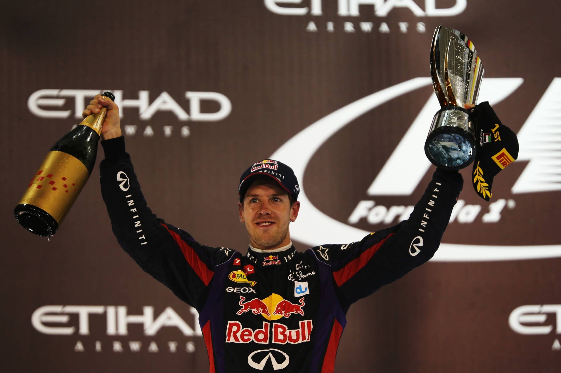 ABU DHABI, UNITED ARAB EMIRATES - NOVEMBER 03:  Sebastian Vettel of Germany and Infiniti Red Bull Racing celebrates on the podium after winning the Abu Dhabi Formula One Grand Prix at the Yas Marina Circuit on November 3, 2013 in Abu Dhabi, United Arab Emirates.  (Photo by Mark Thompson/Getty Images)