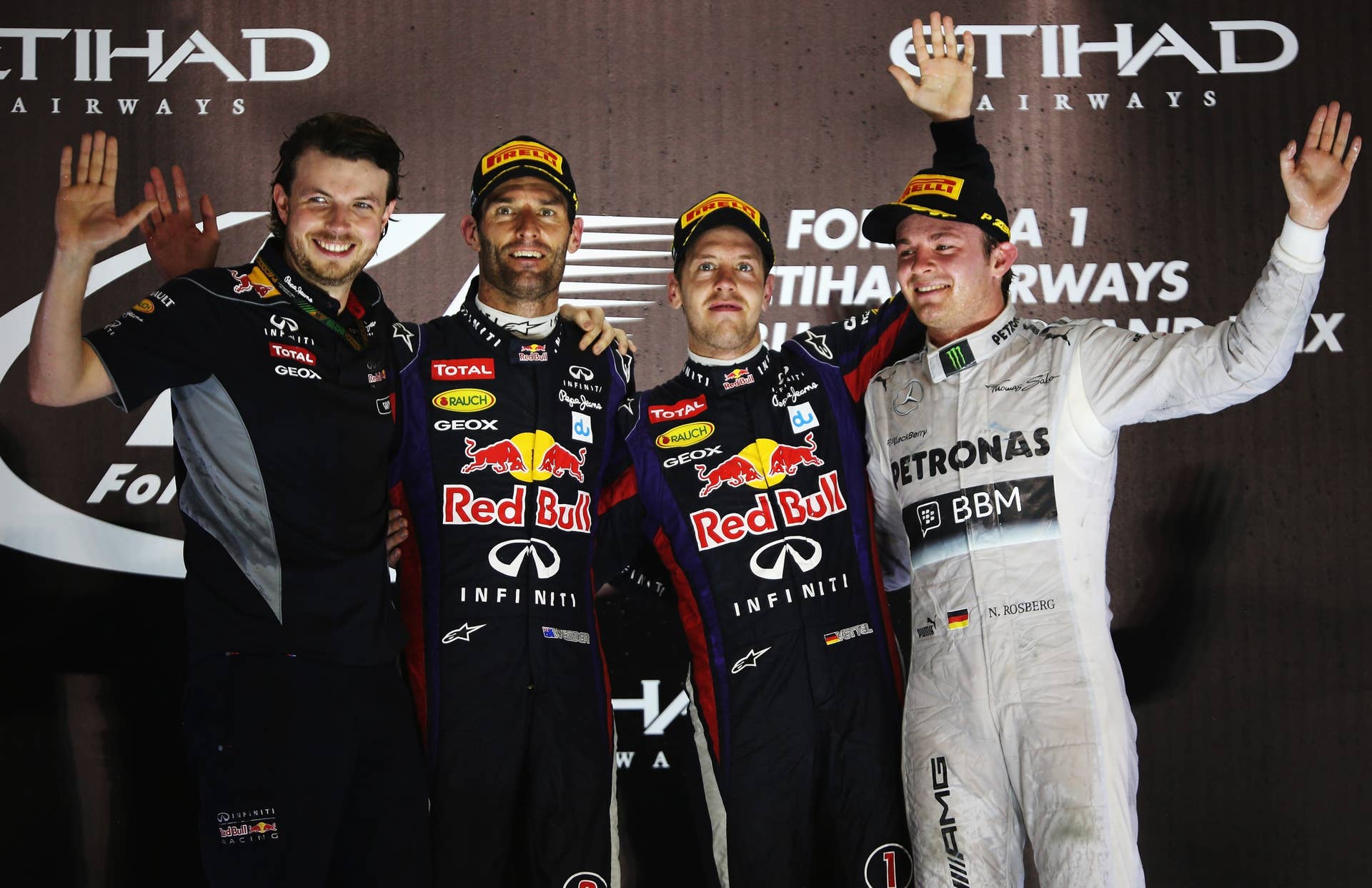 ABU DHABI, UNITED ARAB EMIRATES - NOVEMBER 03: Race winner Sebastian Vettel (C) of Germany and Infiniti Red Bull Racing celebrates on the podium with second placed Mark Webber (2nd L) of Australia and Infiniti Red Bull Racing, third placed Nico Rosberg (R) of Germany and Mercedes GP and Gavin Ward (L) of Infiniti Red Bull Racing after winning the Abu Dhabi Formula One Grand Prix at the Yas Marina Circuit on November 3, 2013 in Abu Dhabi, United Arab Emirates. (Photo by Mark Thompson/Getty Images)