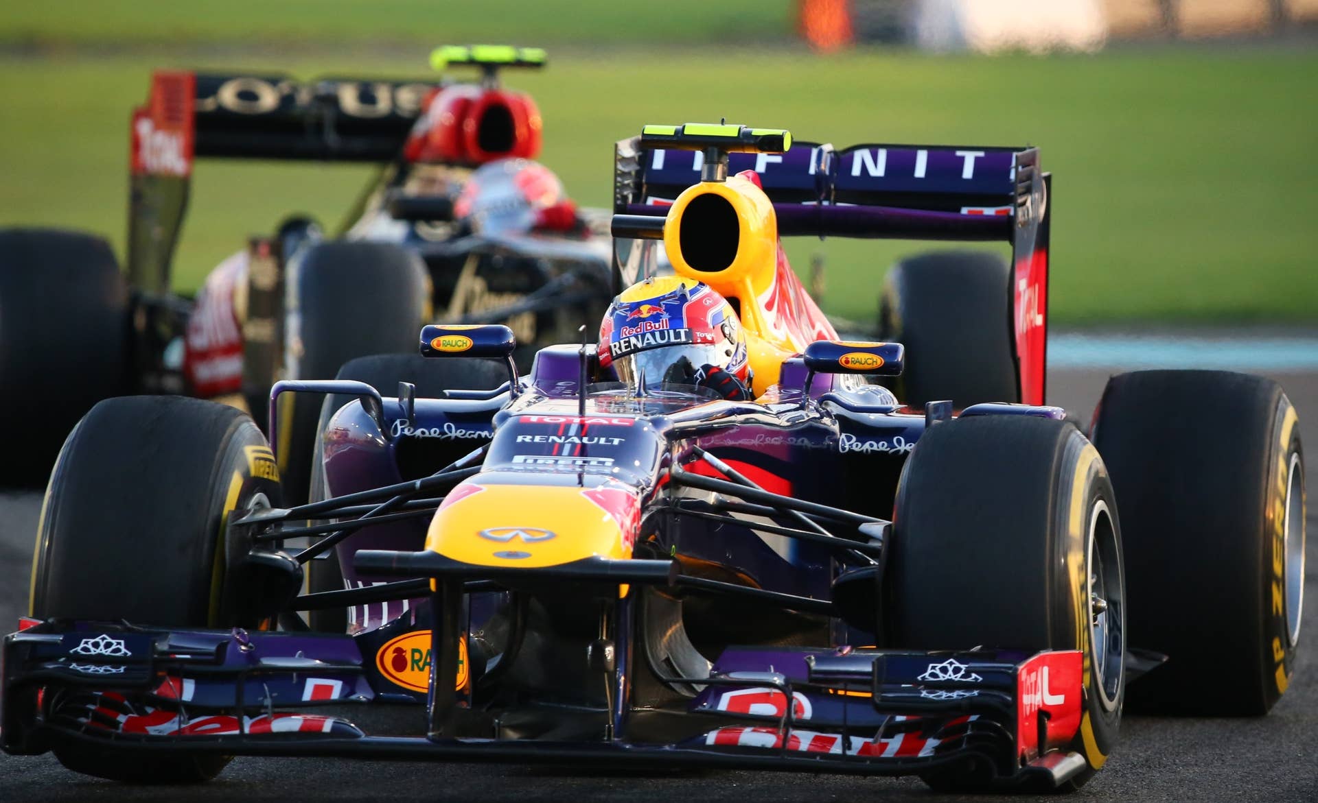 Red Bull Racing's Australian driver Mark Webber and Lotus F1 Team's French driver Romain Grosjean drives at the Yas Marina circuit in Abu Dhabi on November 3, 2013 during the Abu Dhabi Formula One Grand Prix. AFP PHOTO / MARWAN NAAMANI (Photo credit should read MARWAN NAAMANI/AFP/Getty Images)