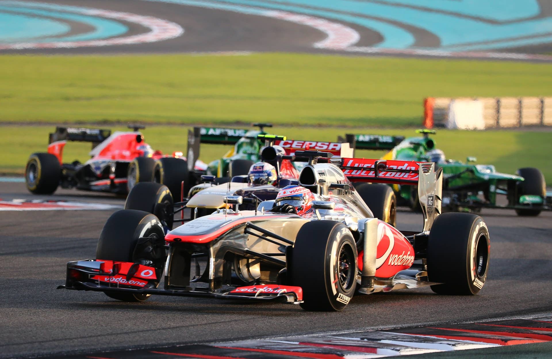 McLaren Mercedes' British driver Jenson Button and Scuderia Toro Rosso's Australian driver Daniel Ricciardo drive at the Yas Marina circuit in Abu Dhabi on November 3, 2013 during the Abu Dhabi Formula One Grand Prix.    AFP PHOTO / MARWAN NAAMANI        (Photo credit should read MARWAN NAAMANI/AFP/Getty Images)