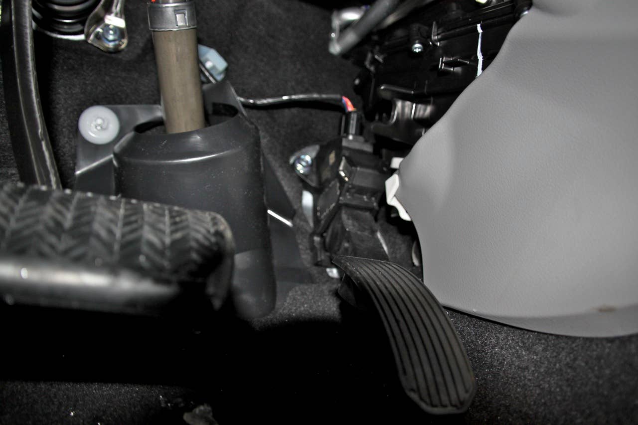 The brake pedal in a 2010 Toyota Corolla. The connector for the pedal position sensor is visible at the top