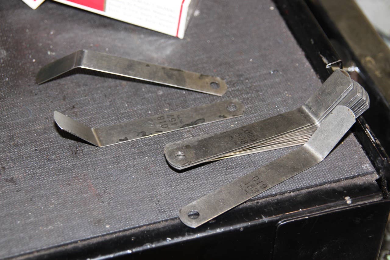A set of feeler gauges, strips of metal of calibrated thickness.