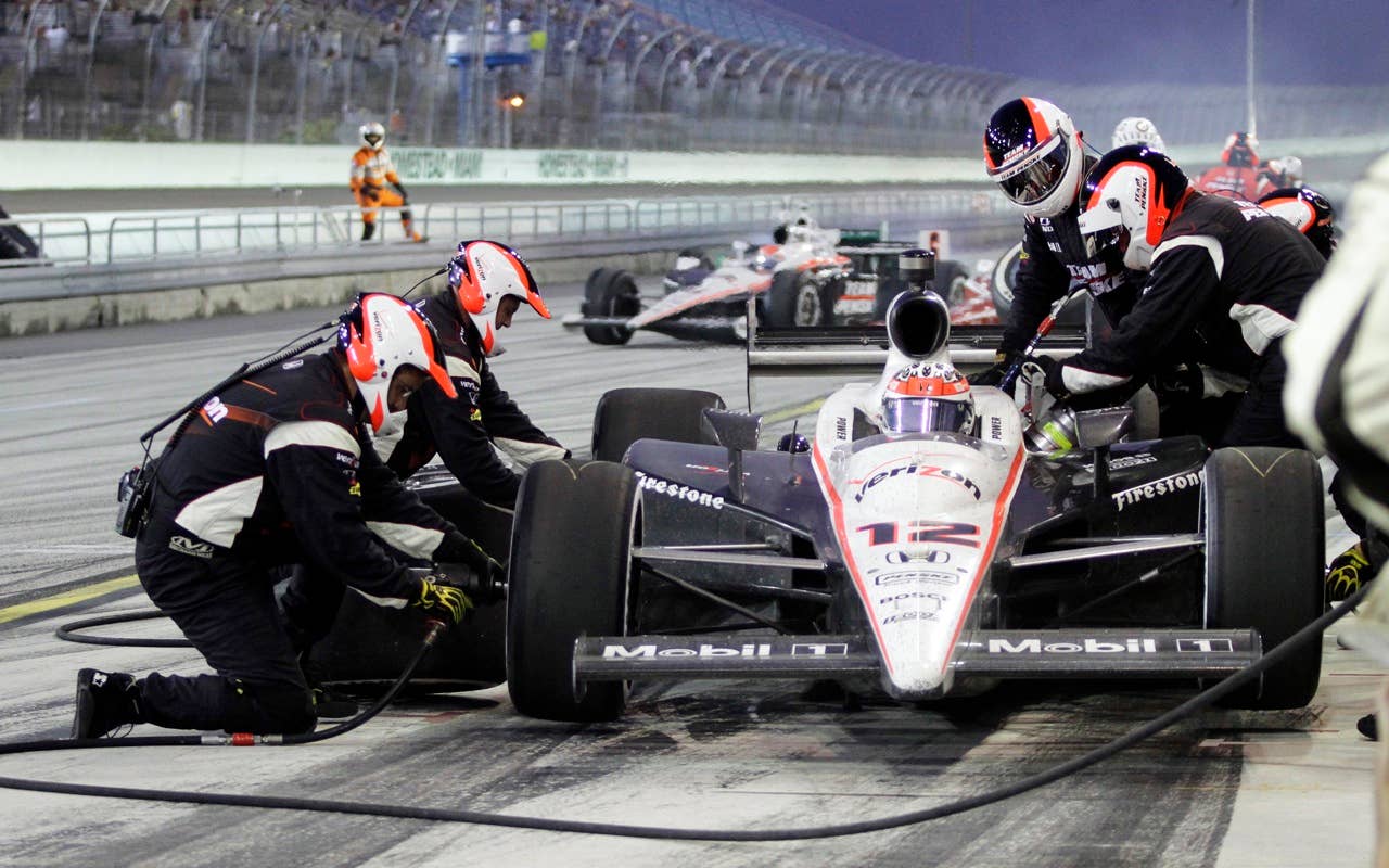 Crew members work on Will Power's, of Australia, car during a pit stop during the IndyCar Series' Indy 300 auto race at Homestead-Miami Speedway in Homestead, Fla., Saturday, Oct. 2, 2010. (AP Photo/Terry Renna)