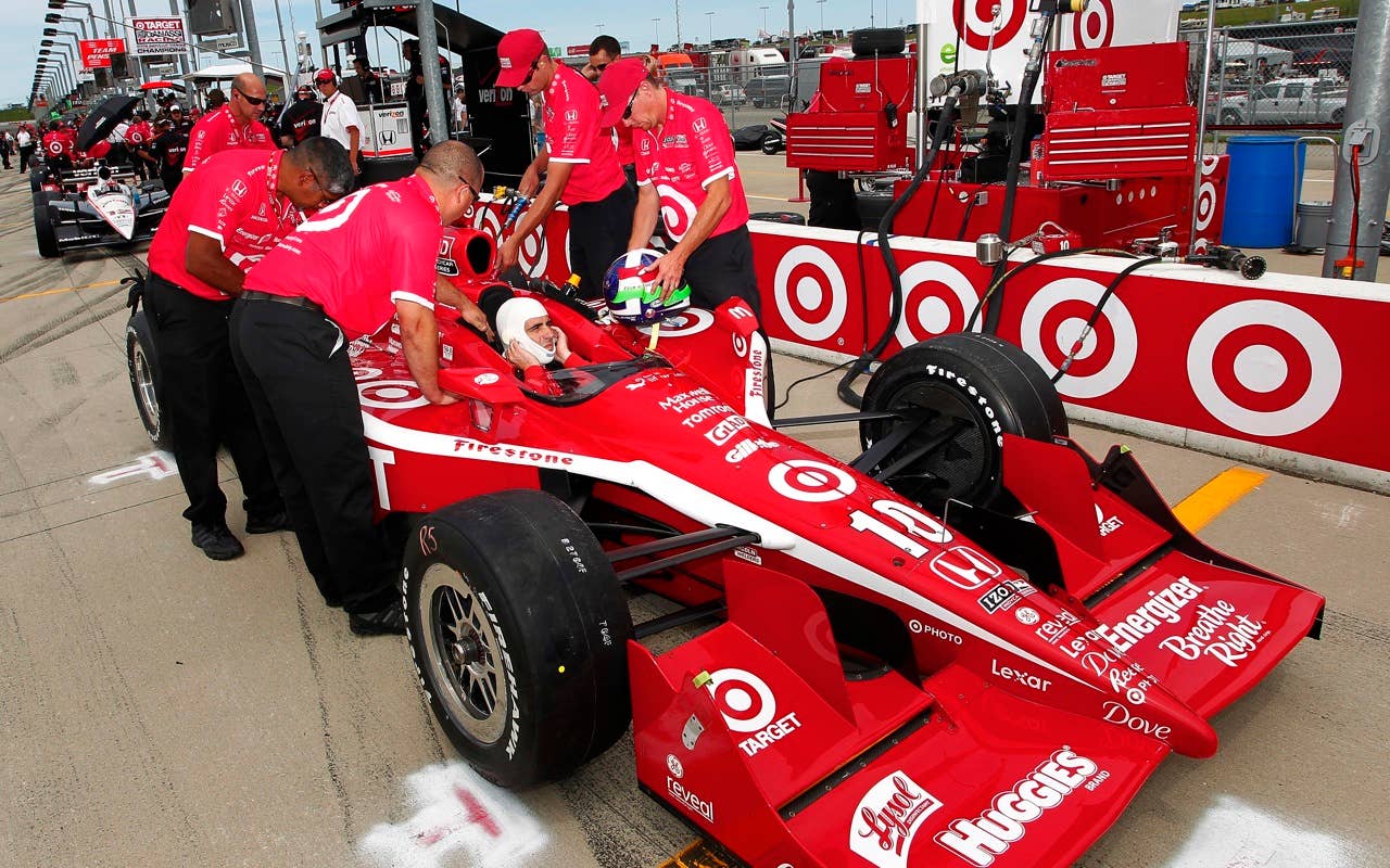 Dario Franchitti of Scotland, driver of the #10 Target Chip Ganassi Racing Dallara Honda, sits in his car as his crew work on the car during practice for the IRL Indycar Series Iowa Corn Indy 250 on June 19, 2010 at the Iowa Speedway in Newton, Iowa.