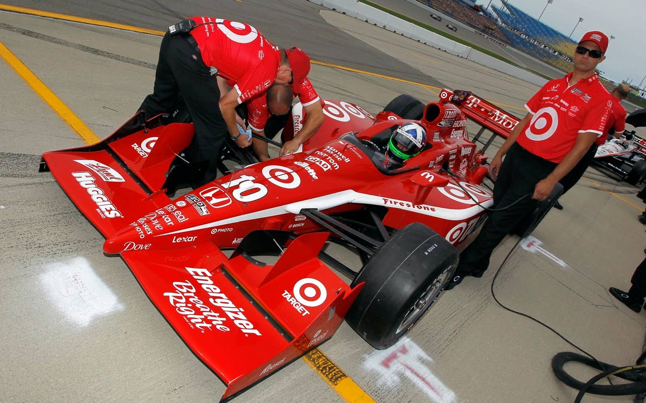 Dario Franchitti of Scotland, driver of the #10 Target Chip Ganassi Racing Dallara Honda, sits in his car as his crew work on the car during practice for the IRL Indycar Series Iowa Corn Indy 250 on June 19, 2010 at the Iowa Speedway in Newton, Iowa.