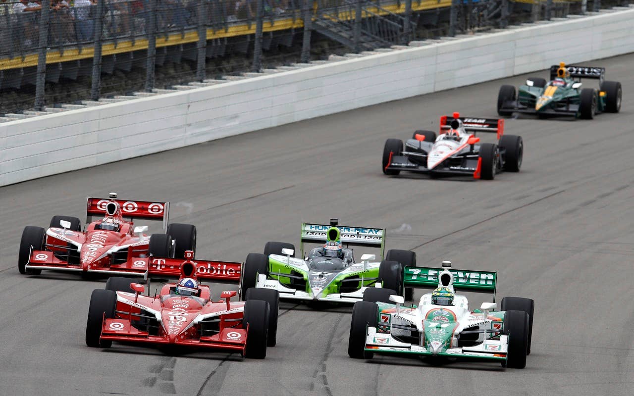 Tony Kanaan of Brazil (R), driver of the #11 7-Eleven Andretti Autosports Dallara Honda, leads Dario Franchitti of Scotland (L), driver of the #10 Target Chip Ganassi Racing Dallara Honda, and a pack of cars during the IRL Indycar Series Iowa Corn Indy 250 on June 20, 2010 in Newton, Iowa.