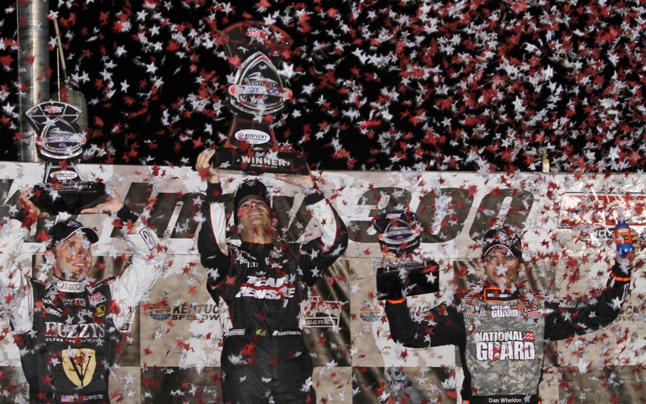 Helio Castroneves, center, of Brazil, is flanked by Ed Carpenter, left, and Dan Wheldon, of England, on the podium after winning the IndyCar Series' Kentucky Indy 300 auto race at Kentucky Speedway in Sparta, Ky., Saturday, Sept. 4, 2010. Carpenter finished second and Wheldon was third. (AP Photo/James Crisp)