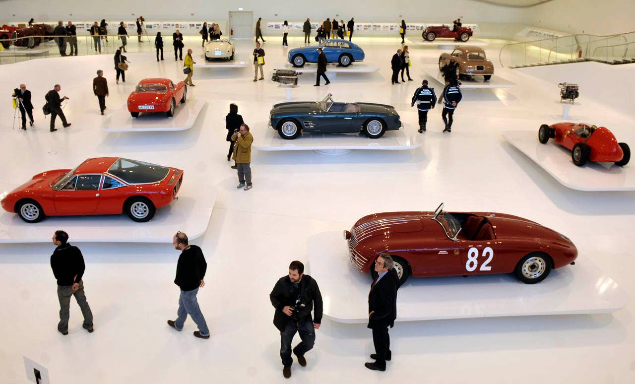 Visitors walk between vintage Farrari sport cars on display at the "Enzo Ferrari Casa Natale", Enzo Ferrari Family House, museum in Modena, Italy, during a media preview, Friday, March 9, 2012. The Museum, that is opening next Saturday March 10, is built in an area around the house where Enzo ferrari was born and spent the first years if his life. (AP Photo/Marco Vasini)