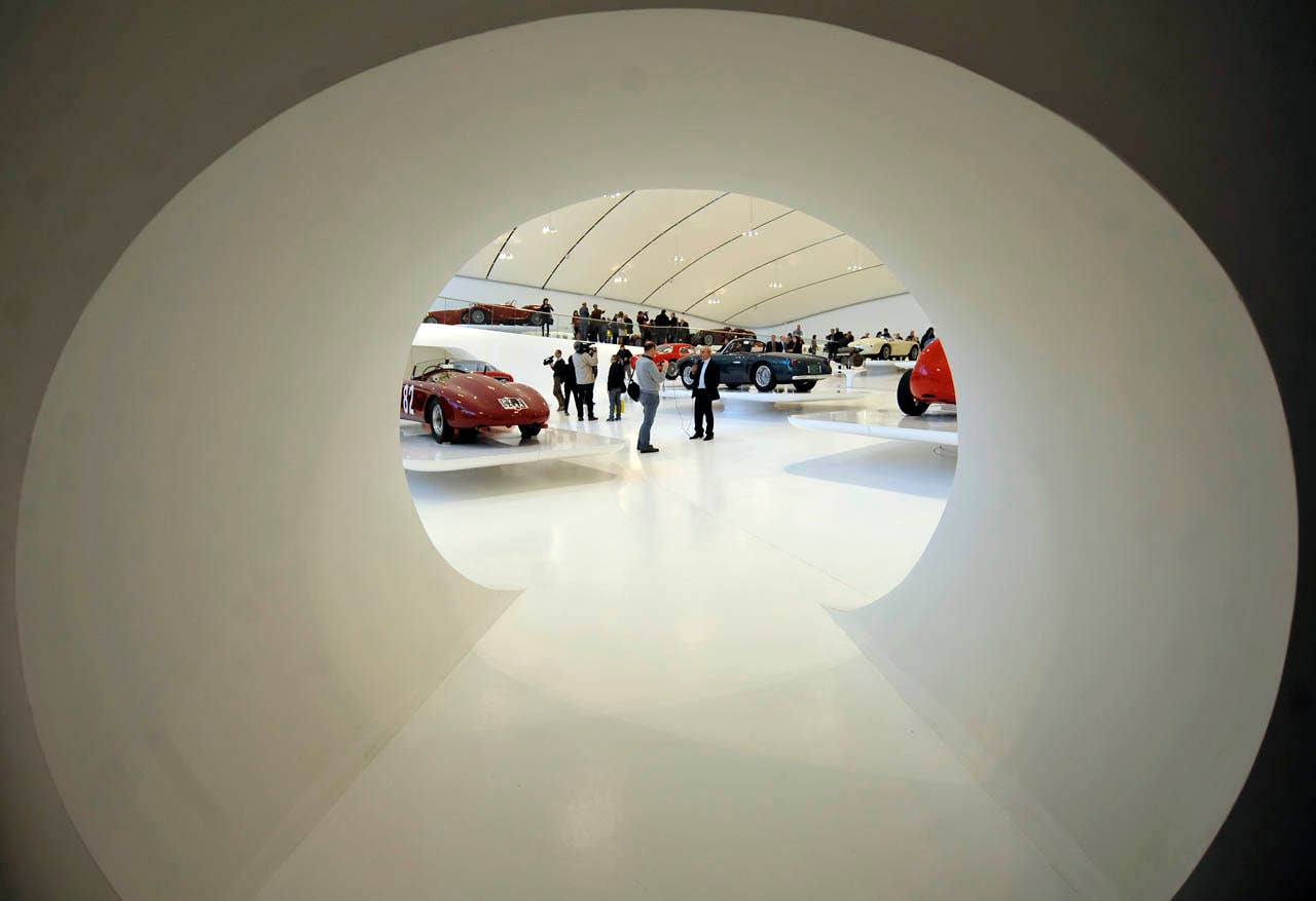 Visitors admire vintage Ferrari sport cars on display at the "Enzo Ferrari Casa Natale", Enzo Ferrari Family House, museum in Modena, Italy, during a media preview, Friday, March 9, 2012. The Museum, that is opening next Saturday March 10, is built in an area around the house where Enzo ferrari was born and spent the first years if his life. (AP Photo/Marco Vasini)