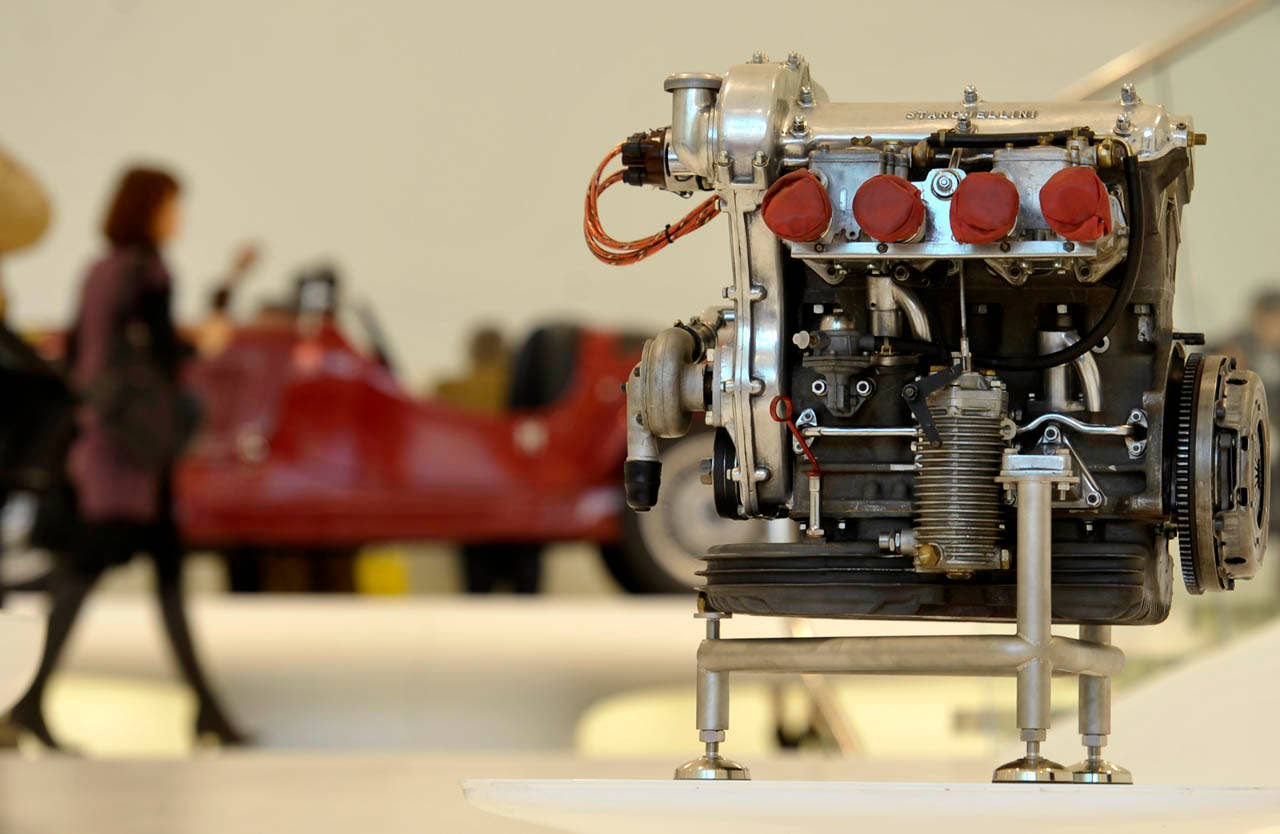 A visitor waks past a vintage Ferrari sport car engine on display at the "Enzo Ferrari Casa Natale", Enzo Ferrari Family House, museum in Modena, Italy, during a media preview, Friday, March 9, 2012. The Museum, that is opening next Saturday March 10, is built in an area around the house where Enzo ferrari was born and spent the first years if his life. (AP Photo/Marco Vasini)