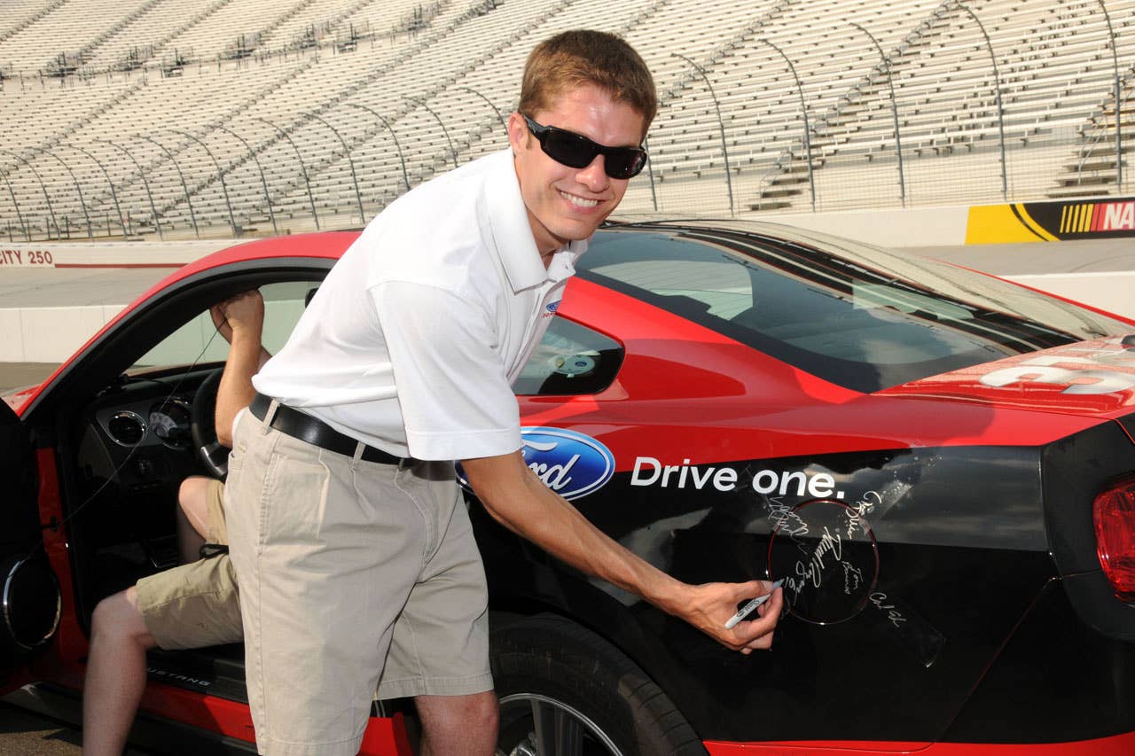 06/23/10 Bristol, Tn. - Ford NASCAR driver David Ragan signs his name to the sealed fuel door on the 2011 Ford Mustang V6 during the Mustang 1000 Lap Challenge, an attempt to drive more than 1,000 laps, or 533 miles, at Bristol Motor Speedway on a single tank of fuel.    2010, Paul Webb