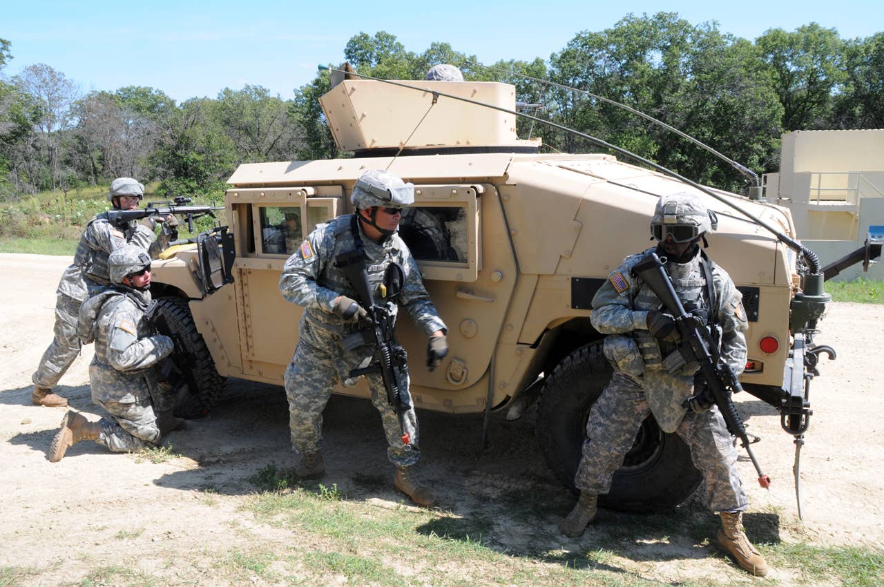 090827-A-9581M-2480  Four Soldiers establish a defensive security posture around the Humvee they just got out of as they begin pursuit of the person who fired on their convoy while inspecting a rural village during a mounted combat patrol exercise on a Fort McCoy training lane. The Soldiers are from the 631st Maintenance Comany mobilizing to deploy in support of Operation Iraqi Freedom. Photo by Tom Michele, federally contracted employee of Team Eagle Systems serving the PAO at Fort McCoy, Wis. Publication or commercial use of this material requires a release by a U.S. Army Public Affairs Officer. Credit U.S. Army photograph.