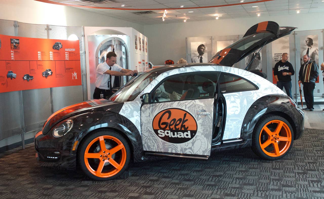 A Geek Squad Agent inspects a "tricked-out" Geekmobile from West Coast Customs at Geek Squad City Friday, Dec. 7, 2012 in Louisville, Ky. (Photo by Joe Imel/Invision for Best Buy/AP Images)