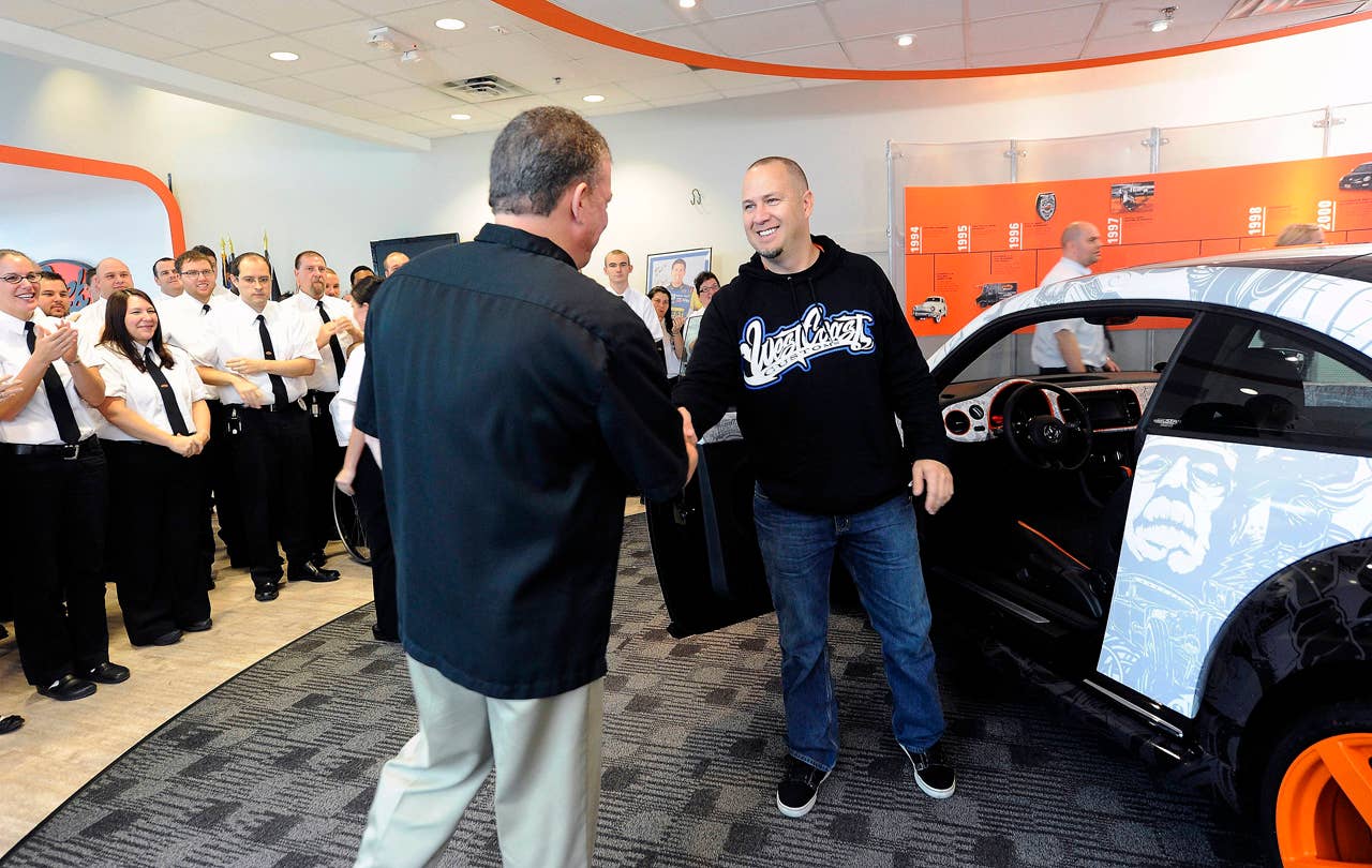 Geek Squad City Mayor Wes Snyder (left), greets Scott Voinovich, of West Coast Customs, at Geek Squad City , where a "tricked-out" Geekmobile modified by West Coast Customs was delivered Friday, Dec. 7, 2012 in Brooks, Ky., just outside of Louisville. (Photo by Joe Imel/Invision for Best Buy/AP Images)