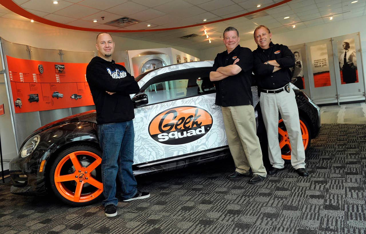 Scott Voinovich (from left), of West Coast Customs, Geek Squad City Mayor Wes Snyder and Randall Ratliff, Geek Squad City Ambassador were on hand when the"tricked-out" Geekmobile arrived at Geek Squad City Friday, Dec. 7, 2012 in Brooks, Ky., just outside of Louisville. (Photo by Joe Imel/Invision for Best Buy/AP Images)