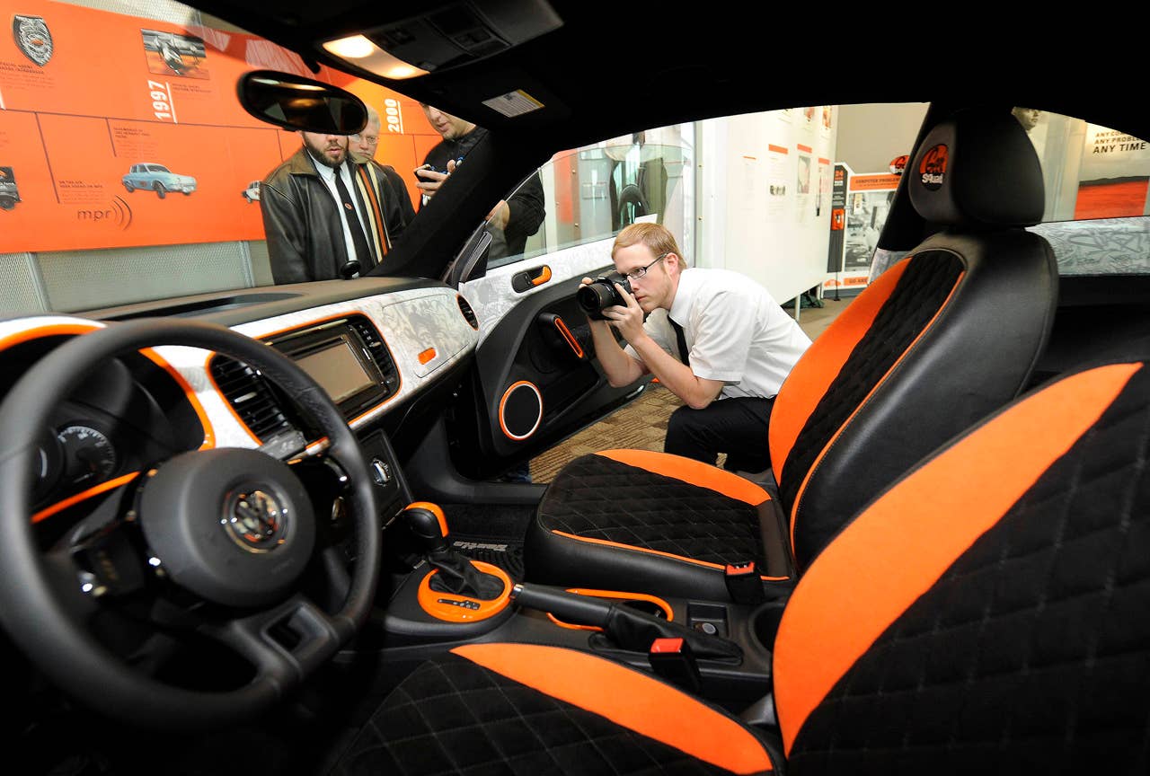 A Geek Squad Agent photographs a "tricked-out" Geekmobile from West Coast Customs at Geek Squad City Friday, Dec. 7, 2012 in Louisville, Ky. (Photo by Joe Imel/Invision for Best Buy/AP Images)