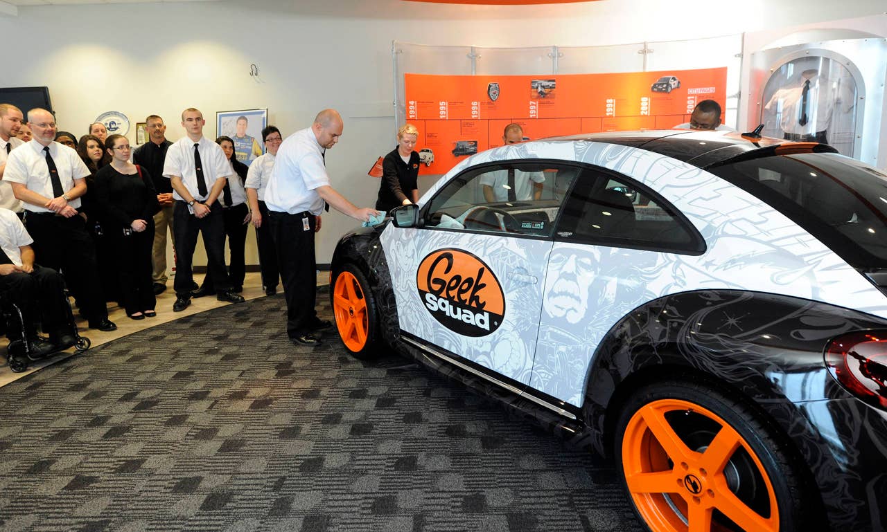 Geek Squad Agents wipe down a "tricked-out" Geekmobile from West Coast Customs at Geek Squad City Friday, Dec. 7, 2012 in Louisville, Ky. (Photo by Joe Imel/Invision for Best Buy/AP Images)