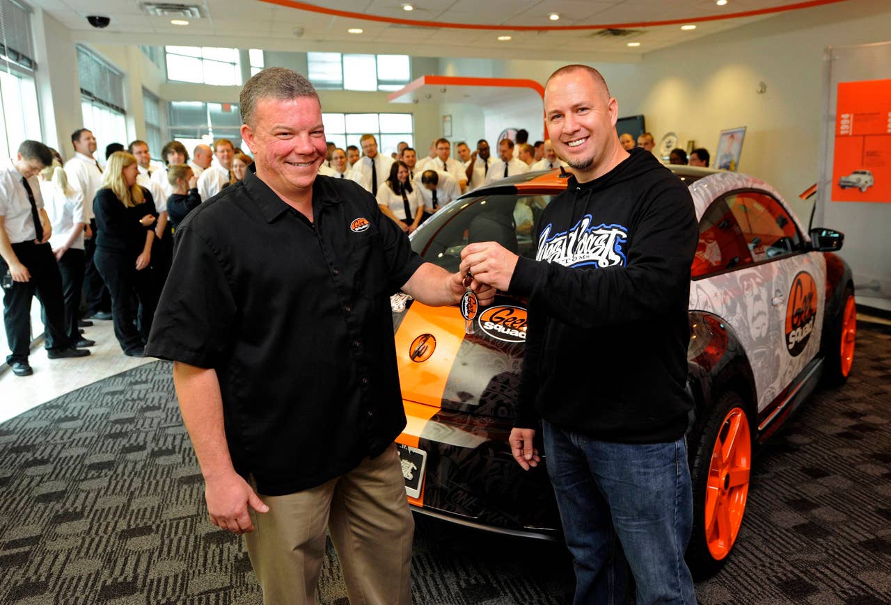 Geek Squad City Mayor Wes Snyder (left), receives the keys of a "tricked-out" Geekmobile, from Scott Voinovich, of West Coast Customs, at Geek Squad City, on Friday, Dec. 7, 2012 in Brooks, Ky., just outside of Louisville. (Photo by Joe Imel/Invision for Best Buy/AP Images)