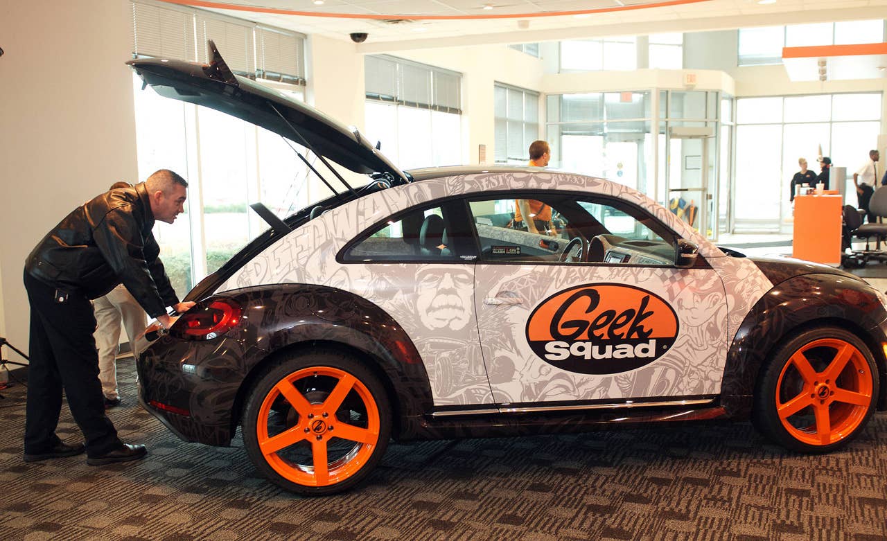 A Geek Squad Agent inspects a "tricked-out" Geekmobile from West Coast Customs at Geek Squad City Friday, Dec. 7, 2012 in Louisville, Ky. (Photo by Joe Imel/Invision for Best Buy/AP Images)