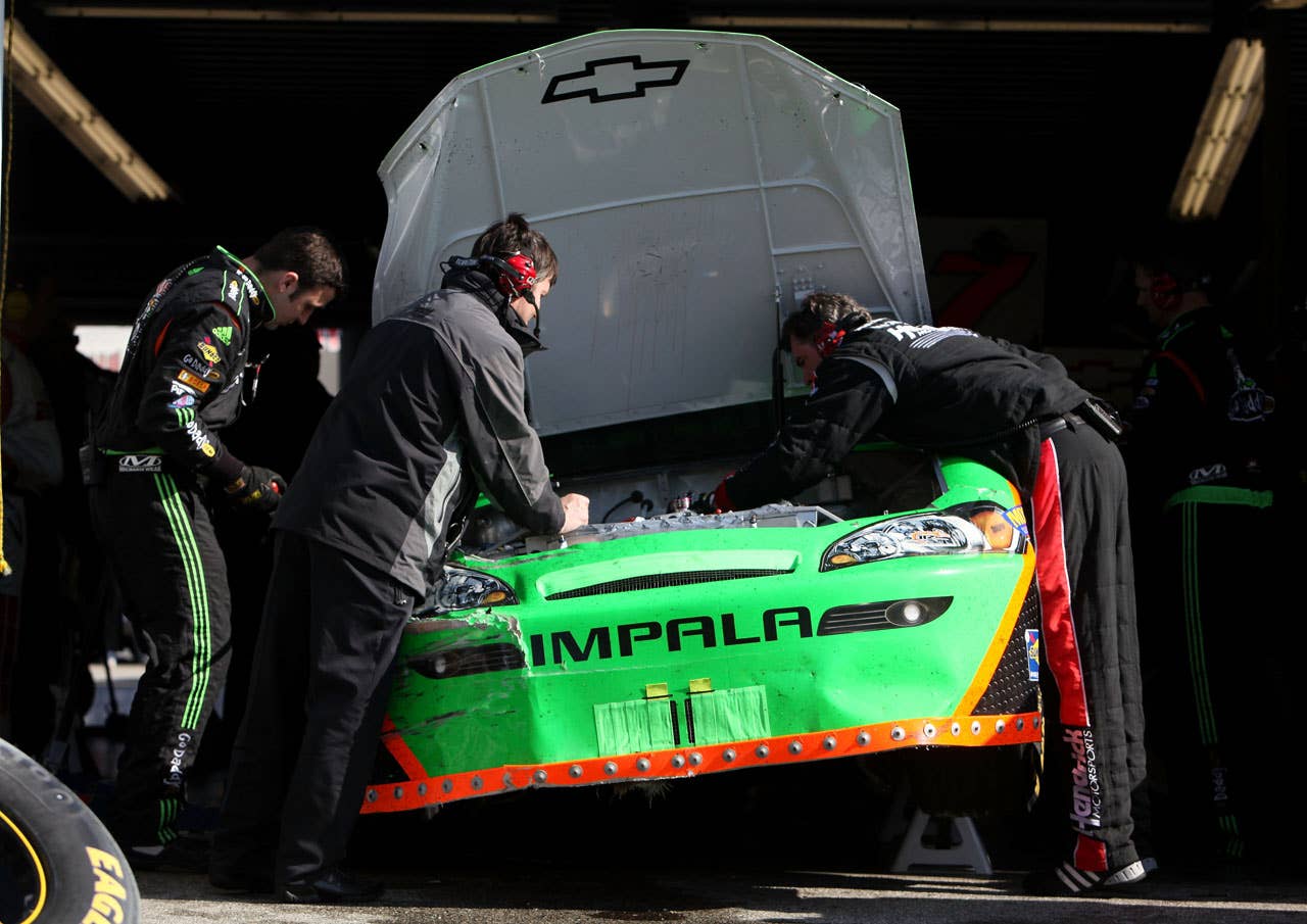 DAYTONA BEACH, FL - FEBRUARY 13:  Crew members for Danica Patrick, driver of the #7 GoDaddy.com Chevrolet, work on the car in the garage area after being involved in a crash during the NASCAR Nationwide Series Drive4COPD 300 at Daytona International Speedway on February 13, 2010 in Daytona Beach, Florida.  (Photo by Jonathan Ferrey/Getty Images for NASCAR)