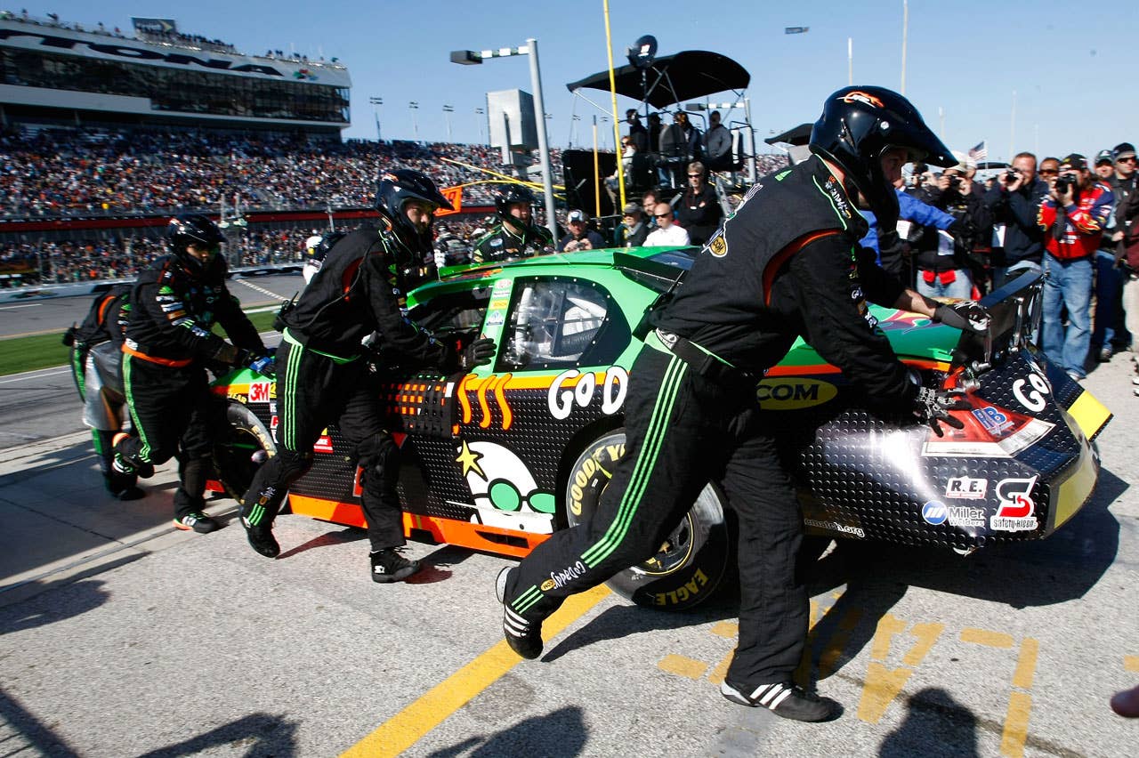 DAYTONA BEACH, FL - FEBRUARY 13:  Crew members push the #7 GoDaddy.com Chevrolet, driven by Danica Patrick, to the garage after a multiple car crash during the NASCAR Nationwide Series Drive4COPD 300 at Daytona International Speedway on February 13, 2010 in Daytona Beach, Florida.  (Photo by Jonathan Ferrey/Getty Images for NASCAR)