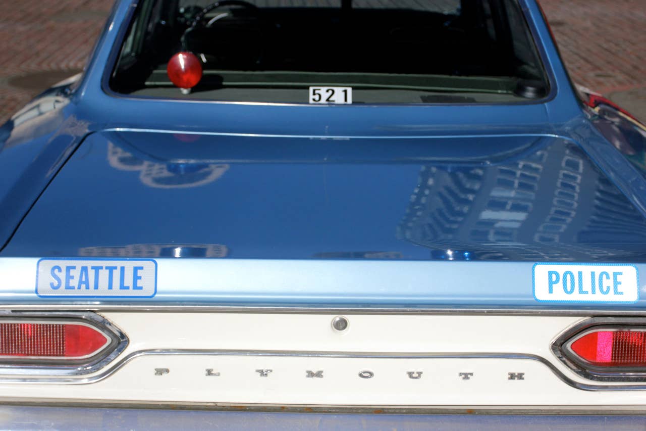 In this image taken Tuesday, April 23, 2013, a 1970 Plymouth Satellite police cruiser is parked in downtown Seattle street while a Seattle Police Department officer Jim Ritter talks to the public. Ritter uses the vintage car as his everyday car and for community outreach for the Seattle Police Department. (AP Photo/Manuel Valdes)