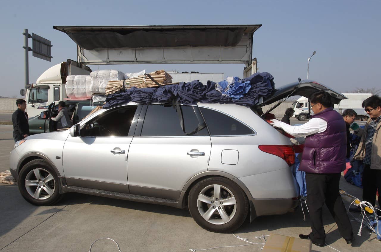 PAJU, SOUTH KOREA - APRIL 27:  South Korean workers unload their products made in North Korea's after arrive from the Kaesong joint industrial complex in North Korea at the inter-Korean transit office on April 27, 2013 in Paju, South Korea. South Korean Unification Ministry annouced yesterday to withdraw all 170 remaining workers from Kaesong industrial complex after failing to persuade the North to restart the talk seeking the normalization of Kaesong's operation.  (Photo by Chung Sung-Jun/Getty Images)