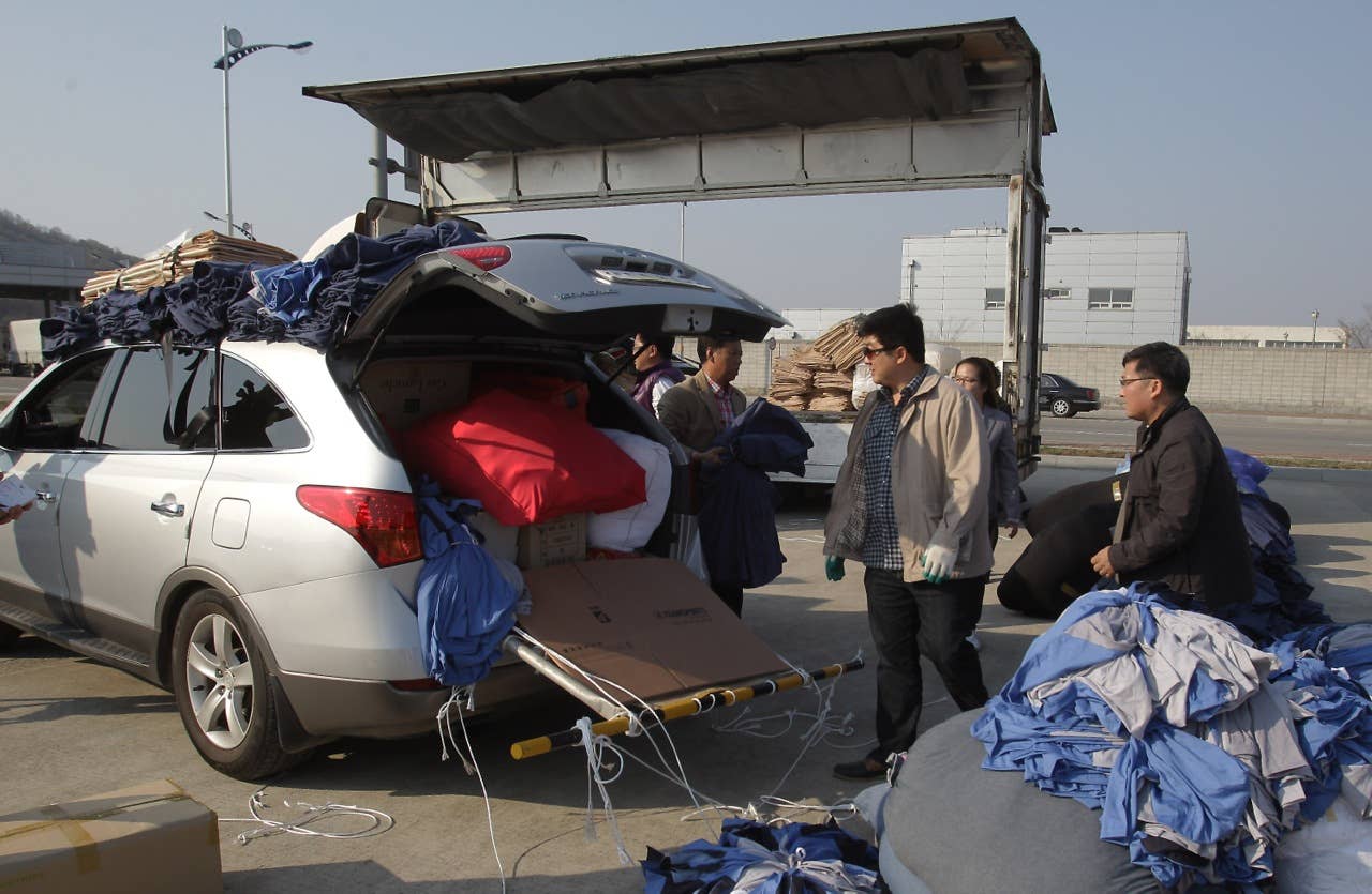 PAJU, SOUTH KOREA - APRIL 27: South Korean workers unload their products made in North Korea's after arrive from the Kaesong joint industrial complex in North Korea at the inter-Korean transit office on April 27, 2013 in Paju, South Korea. South Korean Unification Ministry annouced yesterday to withdraw all 170 remaining workers from Kaesong industrial complex after failing to persuade the North to restart the talk seeking the normalization of Kaesong's operation. (Photo by Chung Sung-Jun/Getty Images)