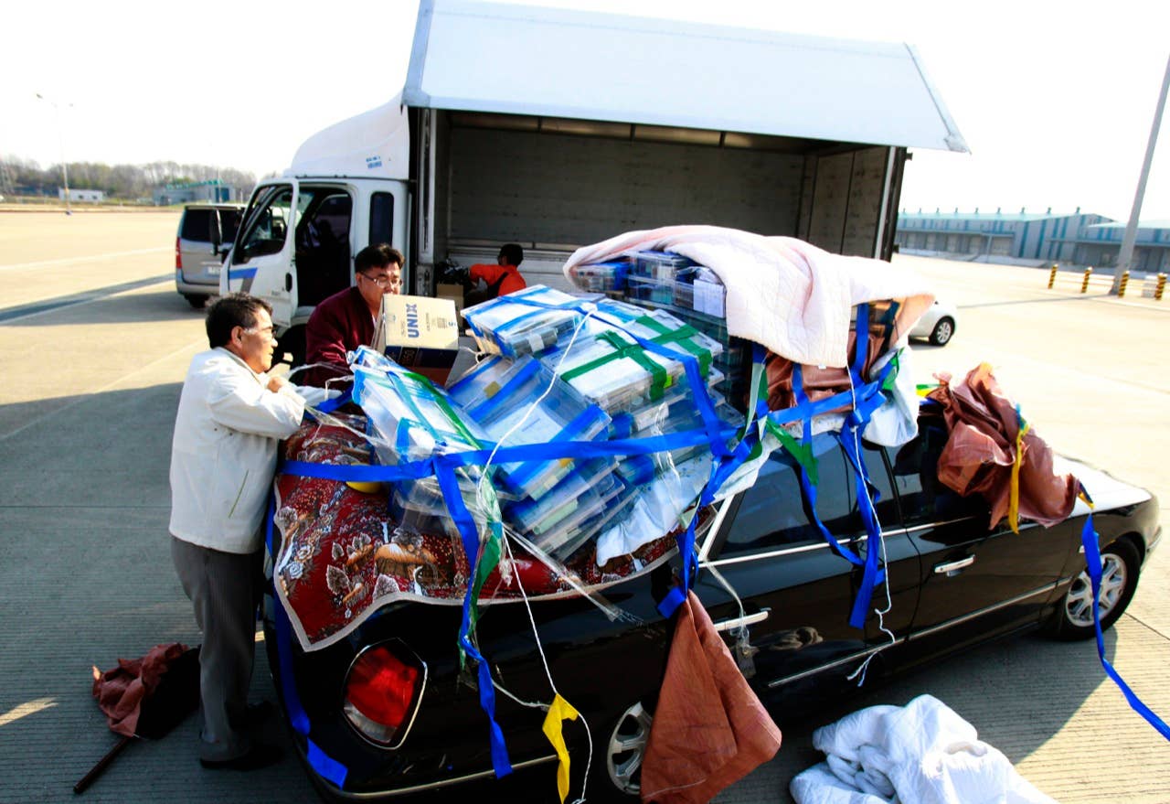 South Korean workers unload their products to a truck as they returned from North Korea's Kaesong industrial complex,  at the customs, immigration and quarantine office near the border village of Panmunjom in Paju, South Korea, Saturday, April 27, 2013. South Korea said Friday that it has decided to withdraw the roughly 175 South Koreans still at a jointly run factory complex in North Korea, raising a major question about the survival of the last symbol of inter-Korean cooperation. (AP Photo/Ahn Young-joon)