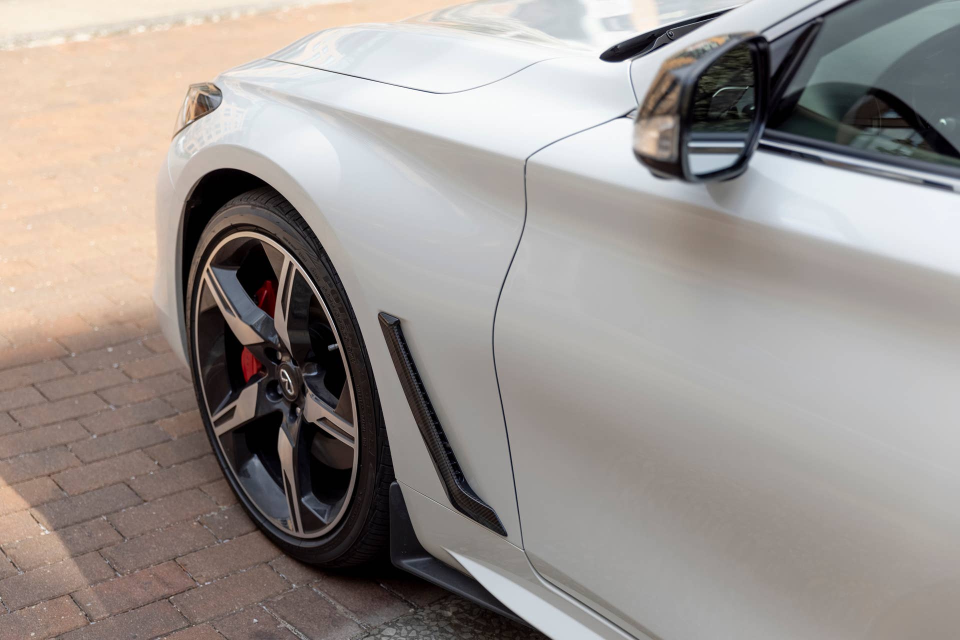 Q60 RED SPORT 400 AWD shown in Majestic White featuring 20-inch accessory alloy wheels