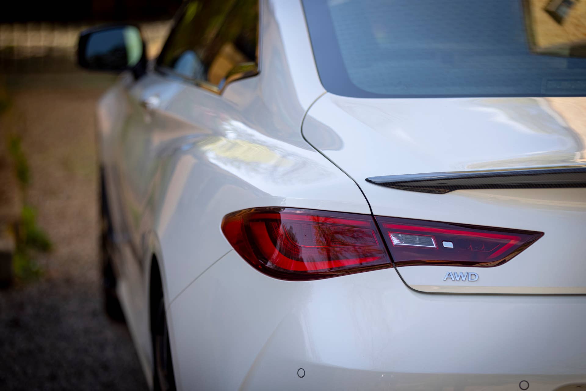 Q60 RED SPORT 400 AWD shown in Majestic White featuring 20-inch accessory alloy wheels