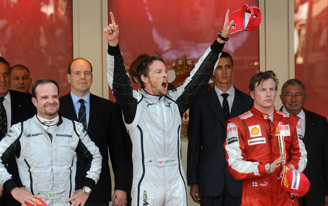 Brawn GP's British driver Jenson Button (C) celebrates with Brawn GP's Brazilian driver Rubens Barrichello (L) and Ferrari's Finnish driver Kimi Raikkonen on the podium of the Monaco racetrack on May 24, 2009 in Monte Carlo, after the Monaco Formula One Grand Prix. Brawn GP's British driver Jenson Button won the race ahead his Brazilian team mate Rubens Barrichello and Ferrari's Finnish driver Kimi Raikkonen. AFP PHOTO / FRED DUFOUR (Photo credit should read FRED DUFOUR/AFP/Getty Images)