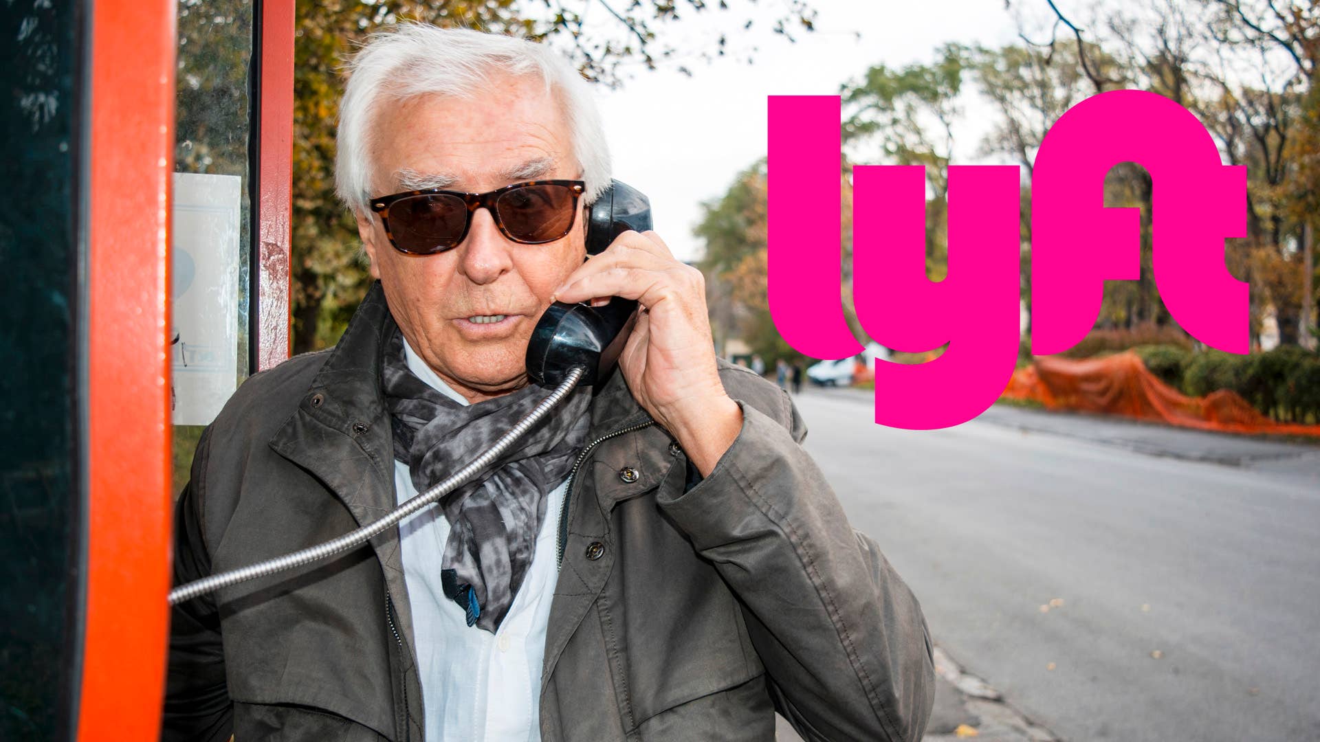 Senior man using public phone to call auto service for broken car on the road.Handsome old man with sunglasses calling help in phone booth on the street.Modern old man portrain talking.Copy space