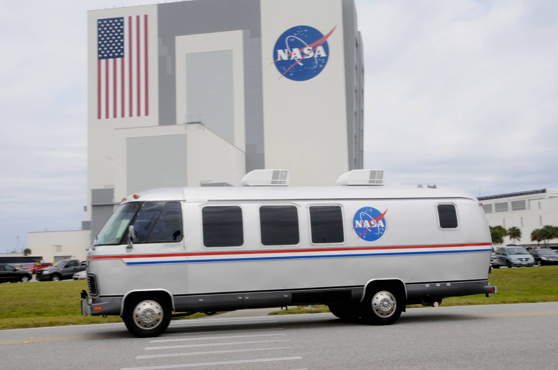 The space shuttle Endeavour astronauts are driven back to crew quarters in the Astrovan past the Vehicle Assembly Building April 29, 2011 at Kennedy Space Center in Florida shortly after the shuttle launch was scrubbed due to technical reasons. The launch was scrubbed due to problems with Auxiliary Power Unit 1 heaters on the Endeavour and has been delayed for a minimun of three days. AFP PHOTO/Bruce WEAVER (Photo credit should read BRUCE WEAVER/AFP via Getty Images)