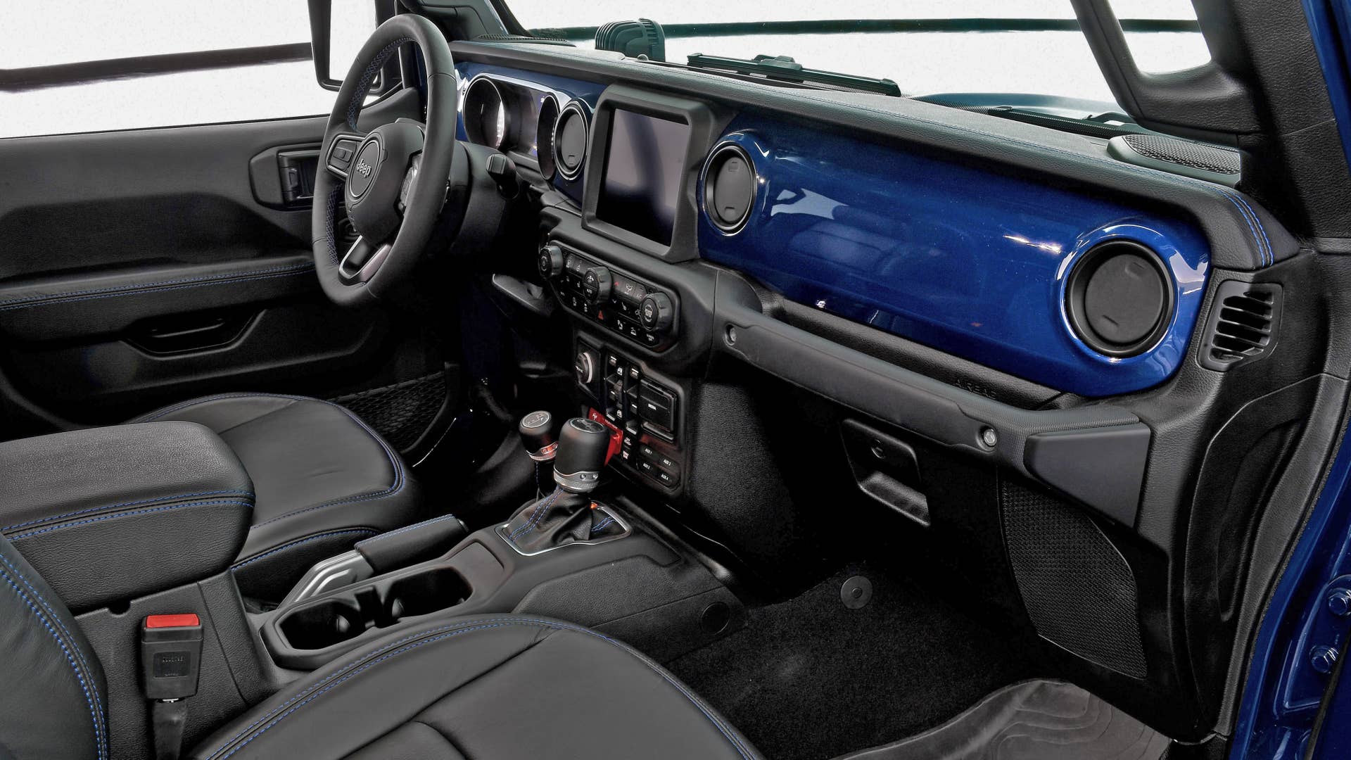 Inside the cabin of the Jeep Gladiator Top Dog concept, the exterior color theme of K-9 Blue and black is continued with an instrument panel that matches the body color. In addition, black Katzkin leather seats, armrests, shifter boots, steering wheel and the parking brake handle are accented with blue stitching.