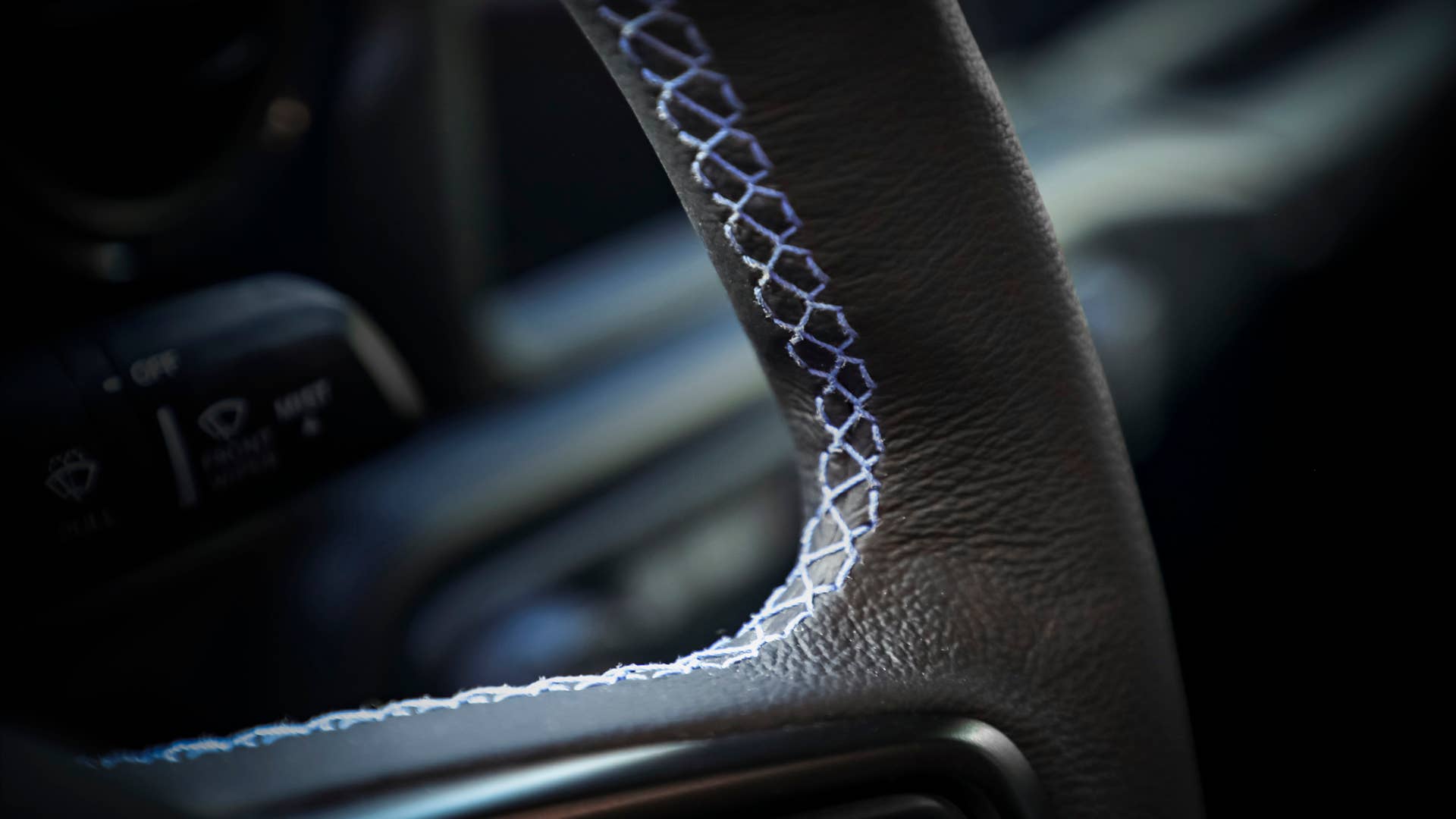 Inside the cabin of the Jeep Gladiator Top Dog Concept, the leather-wrapped steering wheel is accented with blue stitching.