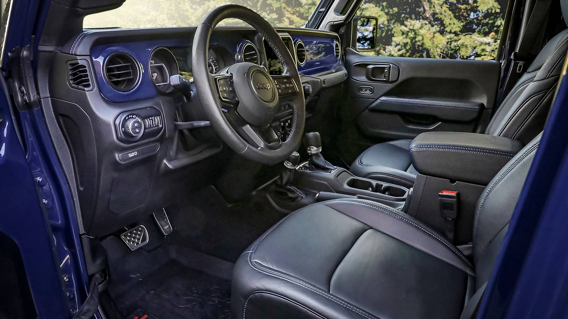 Inside the cabin of the Jeep Gladiator Top Dog concept, the exterior color theme of K-9 Blue and black is continued with an instrument panel that matches the body color. In addition, black Katzkin leather seats, armrests, shifter boots, steering wheel and the parking brake handle are accented with blue stitching.