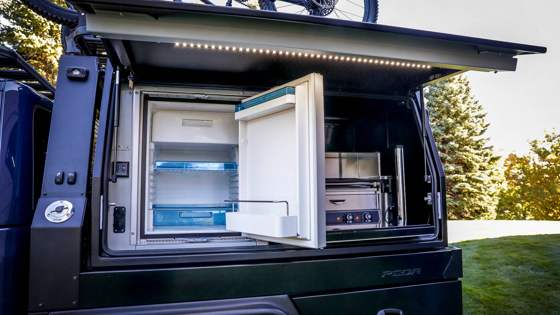 On the driver’s-side of the PCOR storage system of the Jeep Top Dog Concept, a battery-powered refrigerator and electric hot-dog roller grill stand ready to refuel riders for the next section of challenging trails.