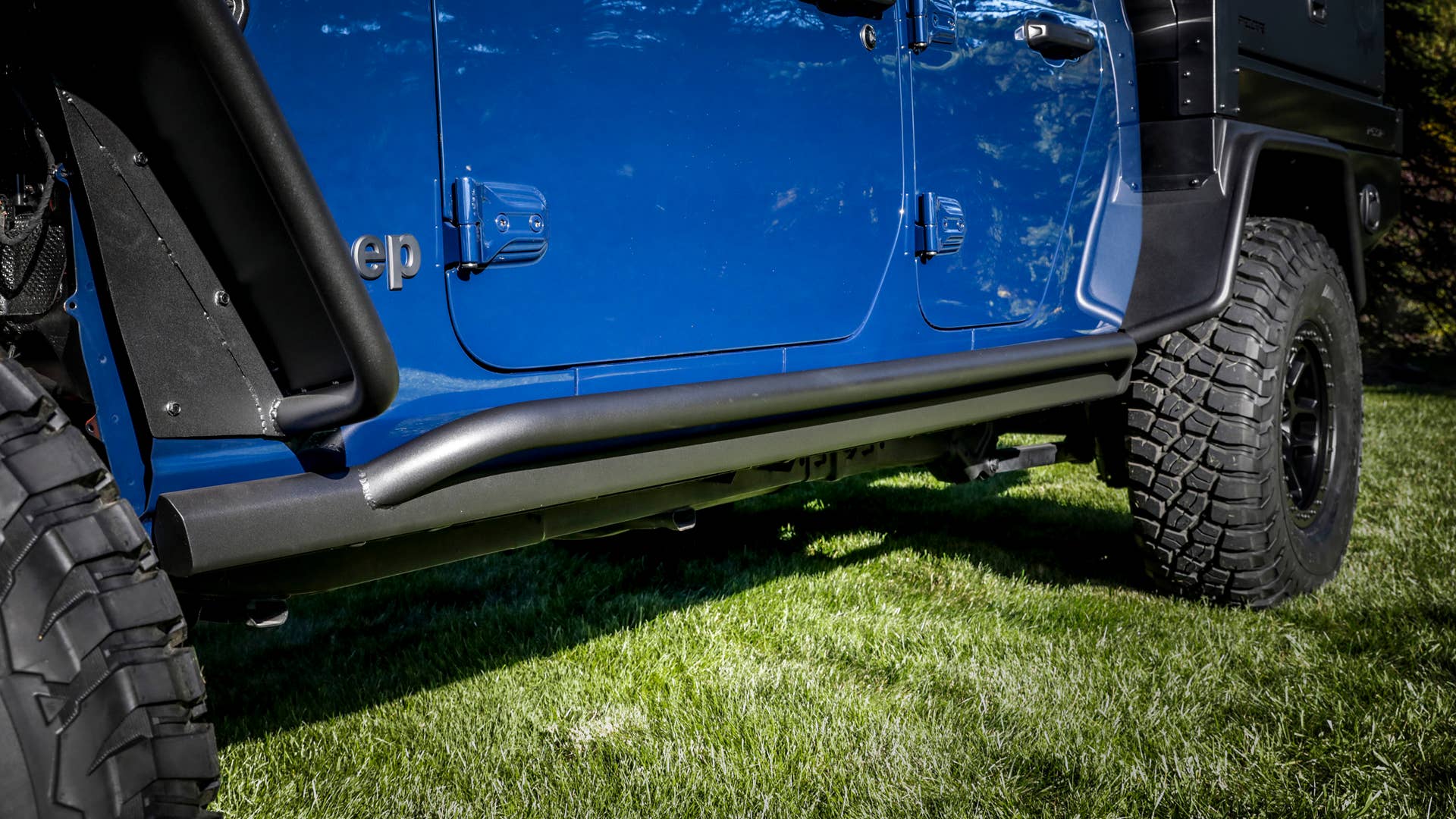 Body sides of the Jeep Gladiator Top Dog Concept are protected by JPP rock rails, customized with welded two-inch steel tubes, similar to the front-grille guard design. Concept steel “high-top” fender flares provide additional clearance at all four corners.