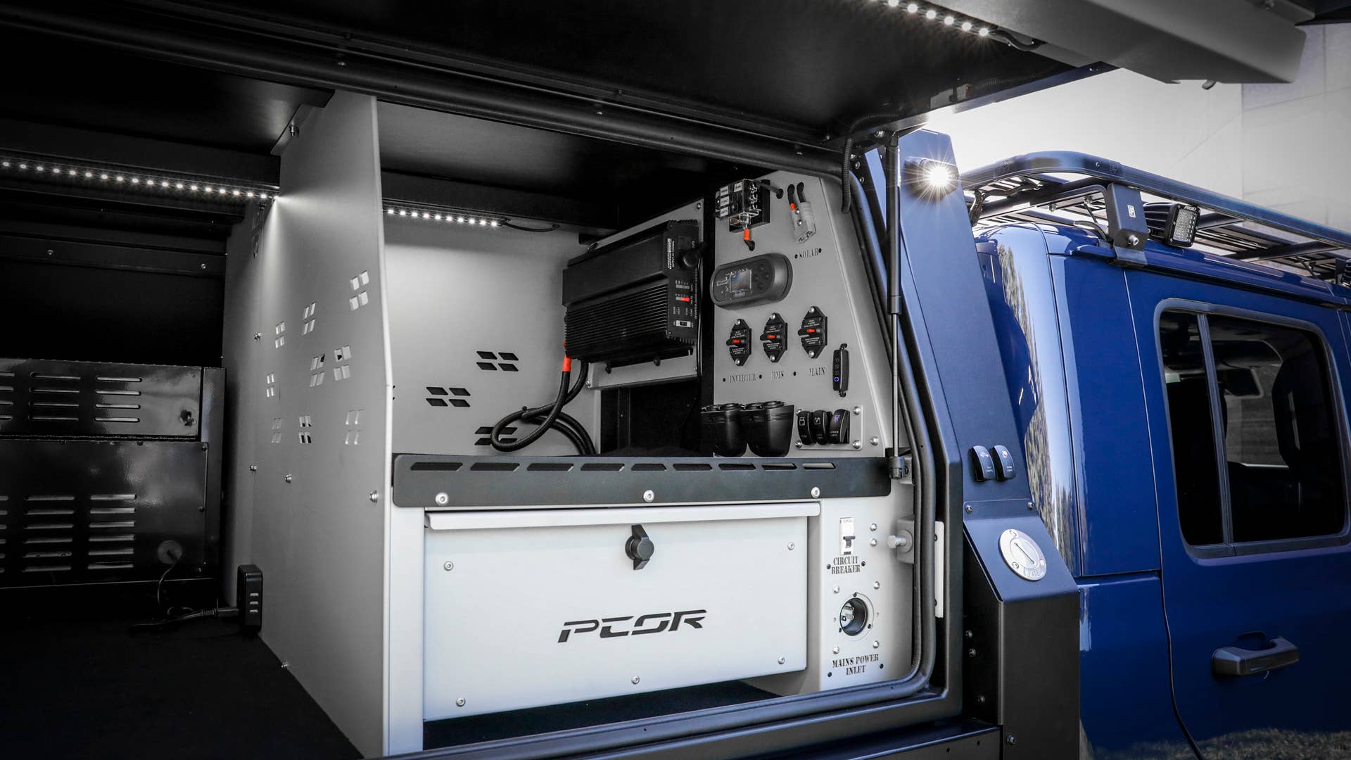 On the passenger-side of the PCOR storage system of the Jeep Gladiator Top Dog Concept, pull-out drawers securely store tools and supplies that mountain bikers need when out on the trails. Vast interior storage shelves, exterior lighting switches and extra power supplies are within easy reach.