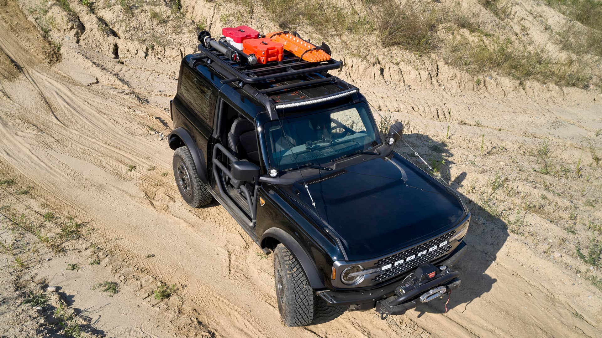 Bronco Two-Door Trail Rig. Designed to be the ultimate hardcore trail rider, this custom build is based on the two-door Badlands™ series. It begins with a Ford Performance modular front bumper, tube doors, beadlock-capable wheels  and 40-inch RIGID® LED lightbar. A Ford Performance by WARN® winch helps rescue your lesser-equipped 4x4 friends. On top, factory roof rails are augmented with a Yakima Platform roof rack system with mounts for a shovel, and Ford Performance by WARN recovery kit and recovery boards. Inside are rugged floor mats and a rear swing-gate-mounted table. (Preproduction image with optional features shown. Available beginning Spring 2021.)